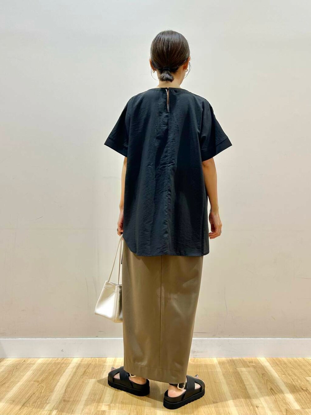 ブラック系のシャツ/ブラウス、ホワイト系のハンドバッグ、ブラック系のサンダルを着用したレディースの夏コーディネートの3枚目の写真