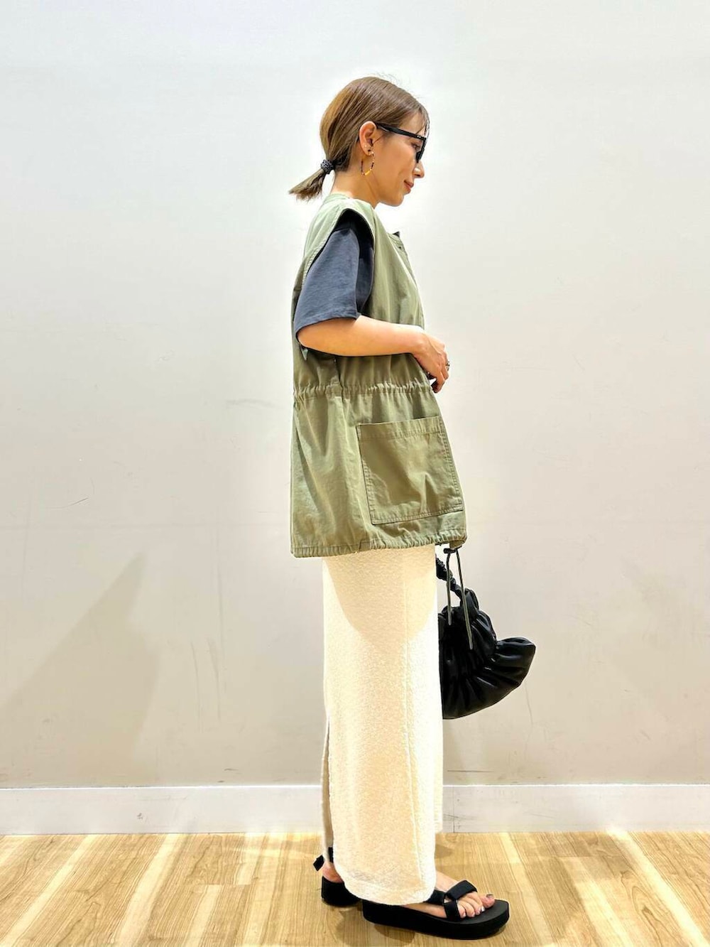 ブラック系のサンダル、ブラック系のハンドバッグ、グリーン系のその他アウターを着用したレディースの夏コーディネートの3枚目の写真