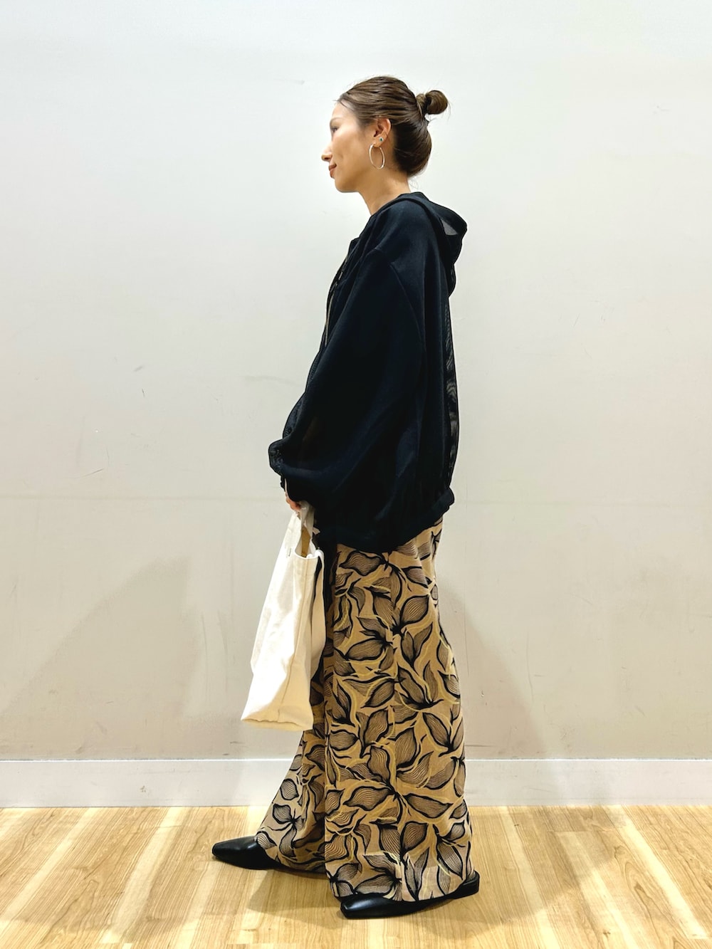 ブラック系のマウンテンパーカー、ブラック系のニット/セーター、ブラウン系のその他パンツを着用したレディースの春コーディネートの2枚目の写真