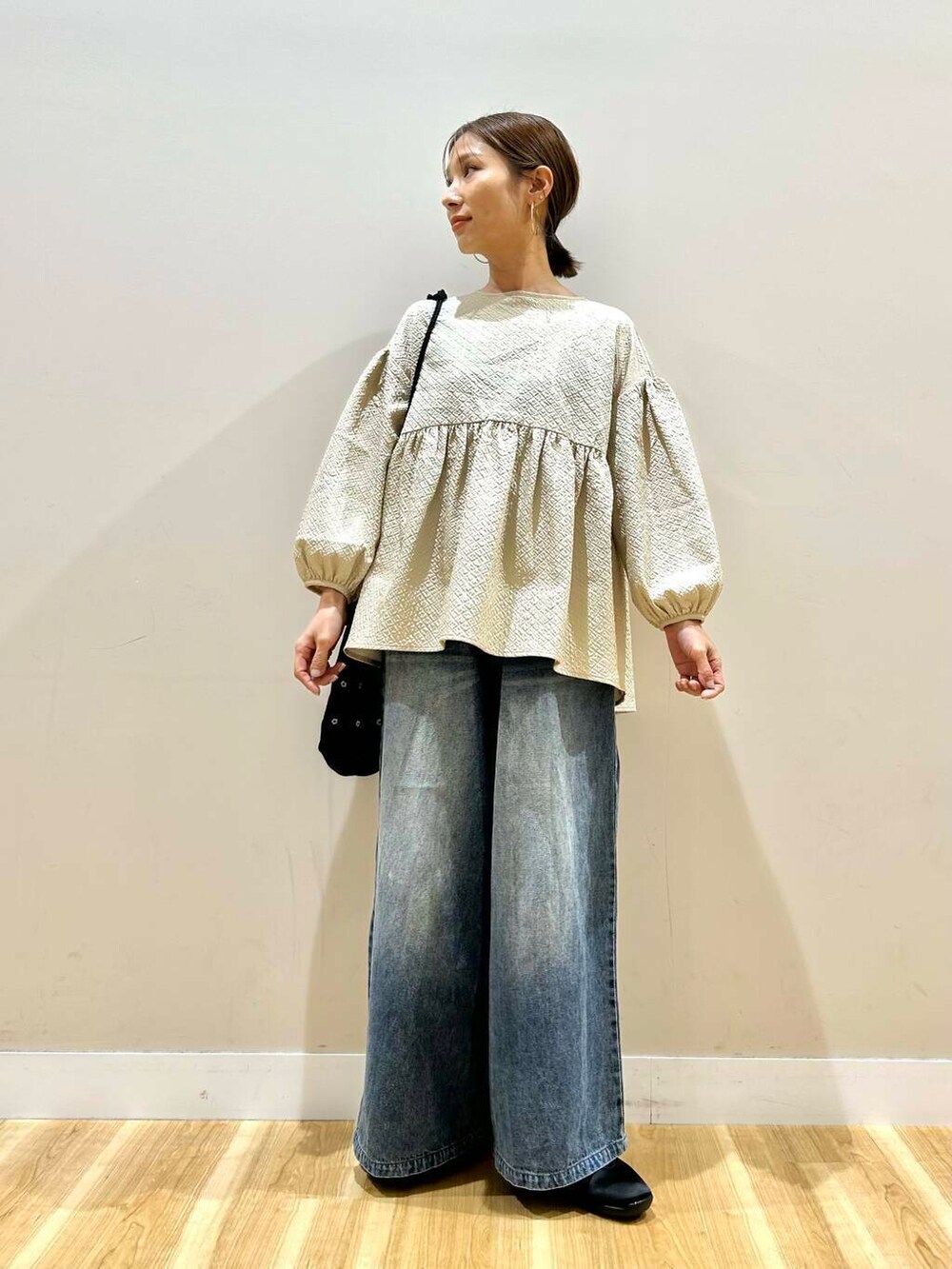 ブラック系のショルダーバッグ、ブルー系のデニムパンツ、ベージュ系のシャツ/ブラウスを着用したレディースの春コーディネートの6枚目の写真