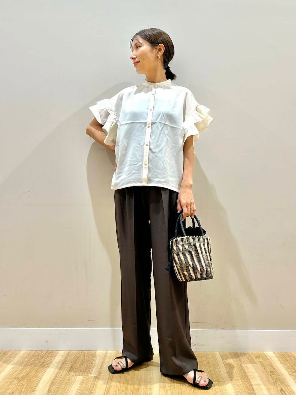 ブラック系のハンドバッグ、ブラック系のサンダル、ブラウン系のその他パンツを着用したレディースの夏コーディネートの2枚目の写真