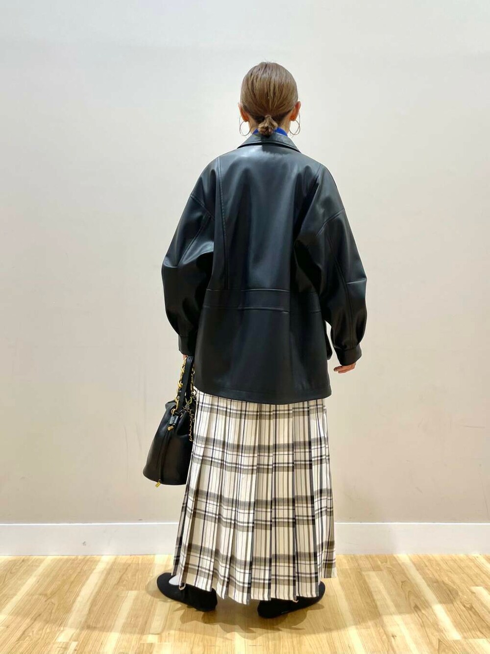 ブラック系のショルダーバッグ、ブラック系のその他アウター、ブルー系のニット/セーターを着用したレディースの冬コーディネートの3枚目の写真