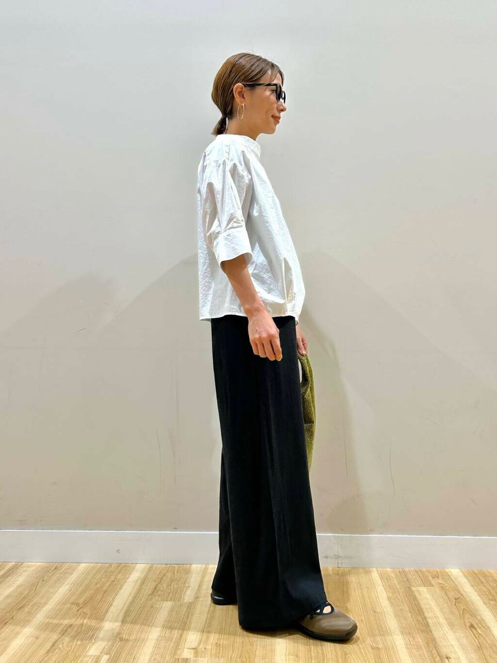 ゴールド系のトートバッグ、ブラック系のその他パンツ、ホワイト系のシャツ/ブラウスを着用したレディースの春コーディネートの4枚目の写真