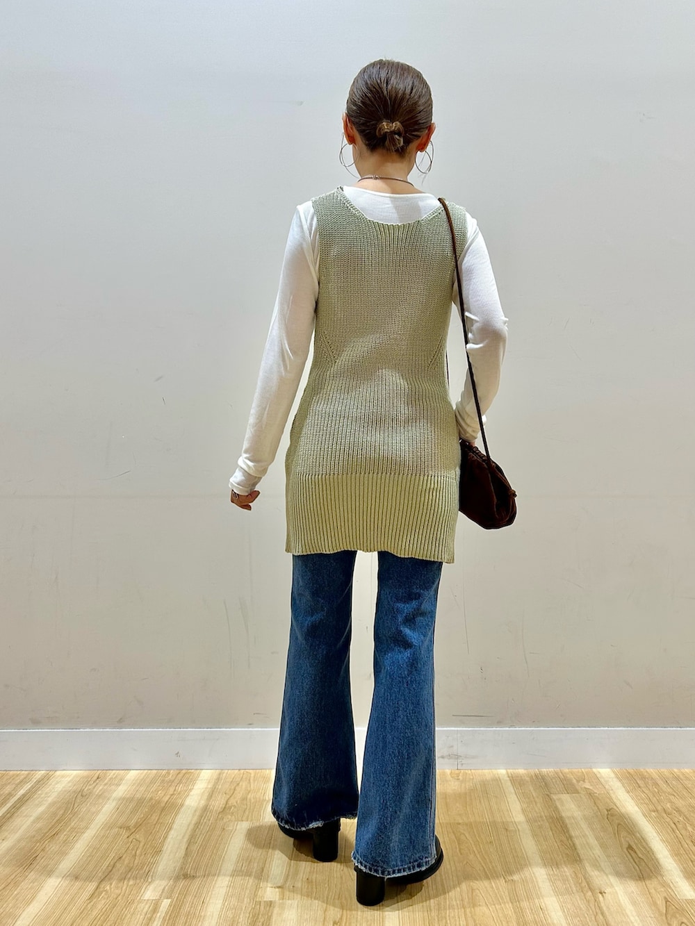 ベージュ系のベスト、ブルー系のデニムパンツ、ブラック系のその他シューズを着用したレディースの春コーディネートの3枚目の写真