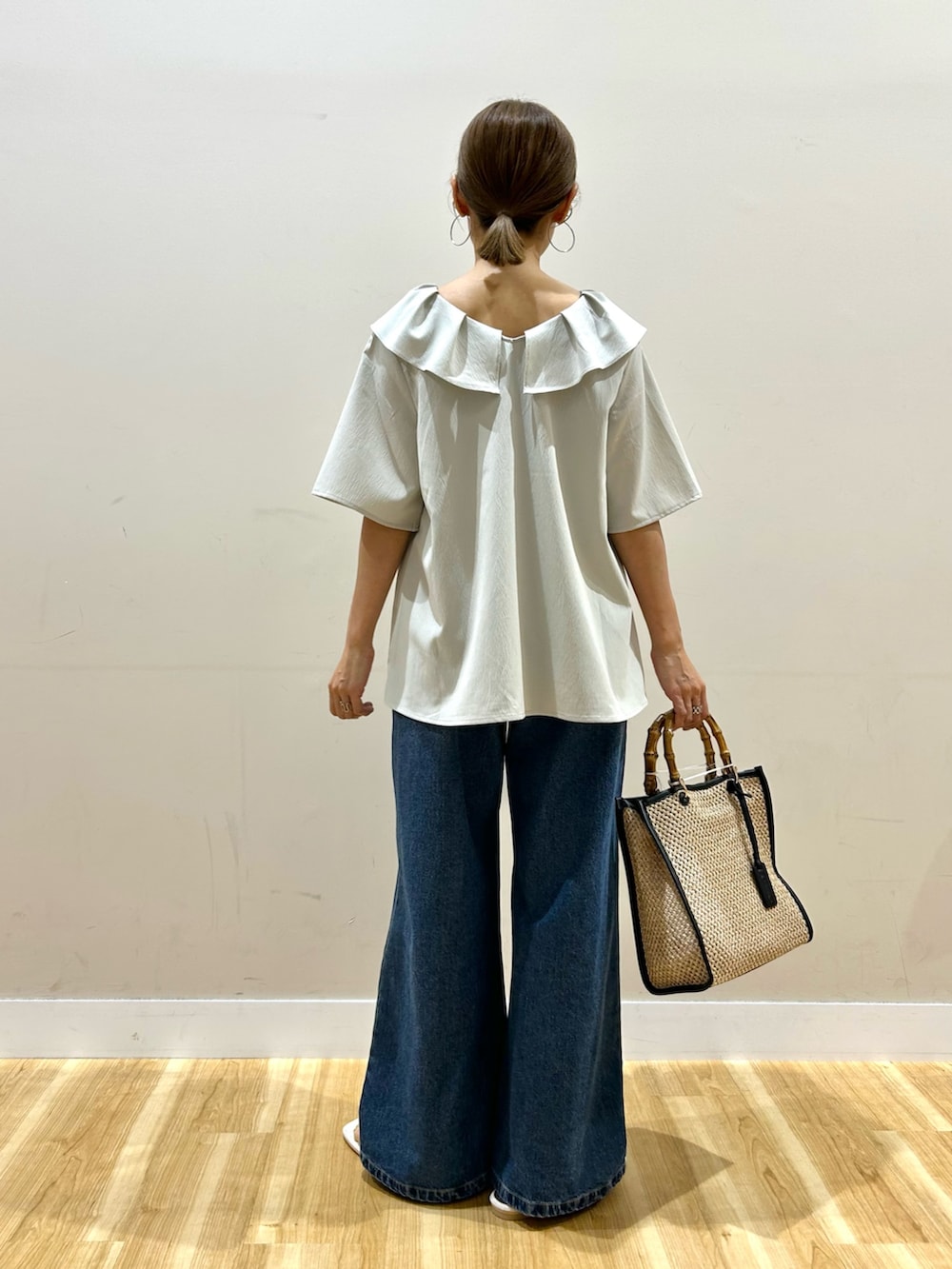 グレー系のシャツ/ブラウス、ブルー系のデニムパンツ、ブラック系のショルダーバッグを着用したレディースの夏コーディネートの4枚目の写真