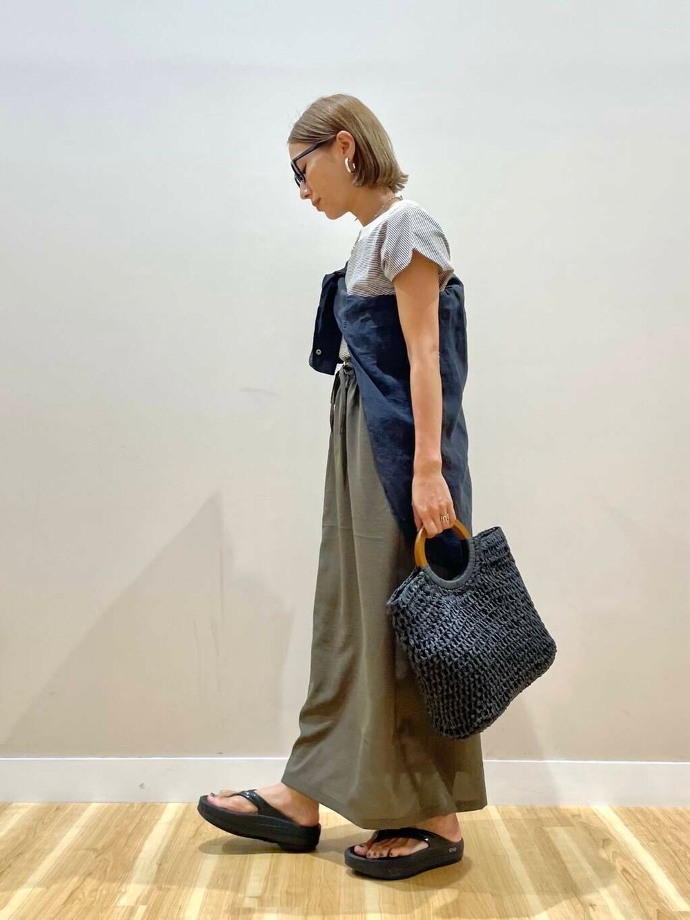 ブラック系のトートバッグ、ブラウン系のTシャツ/カットソー、ブラウン系のスカートを着用したレディースの夏コーディネートの2枚目の写真