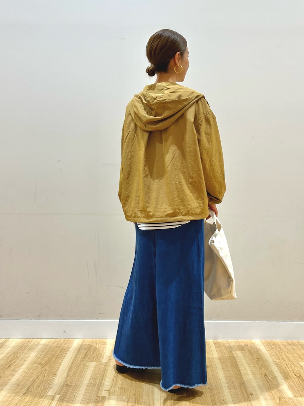 イエロー系のブルゾン、ホワイト系のTシャツ/カットソー、ブルー系のスカートを着用したレディースの春コーディネートの3枚目の写真