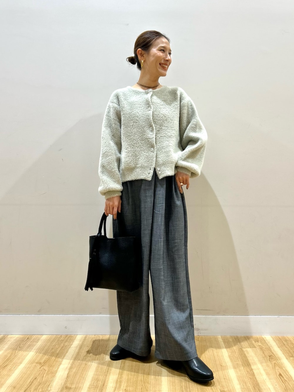 ベージュ系のニット/セーター、ブラック系のその他パンツ、ブラック系のトートバッグを着用したレディースの秋コーディネートの4枚目の写真
