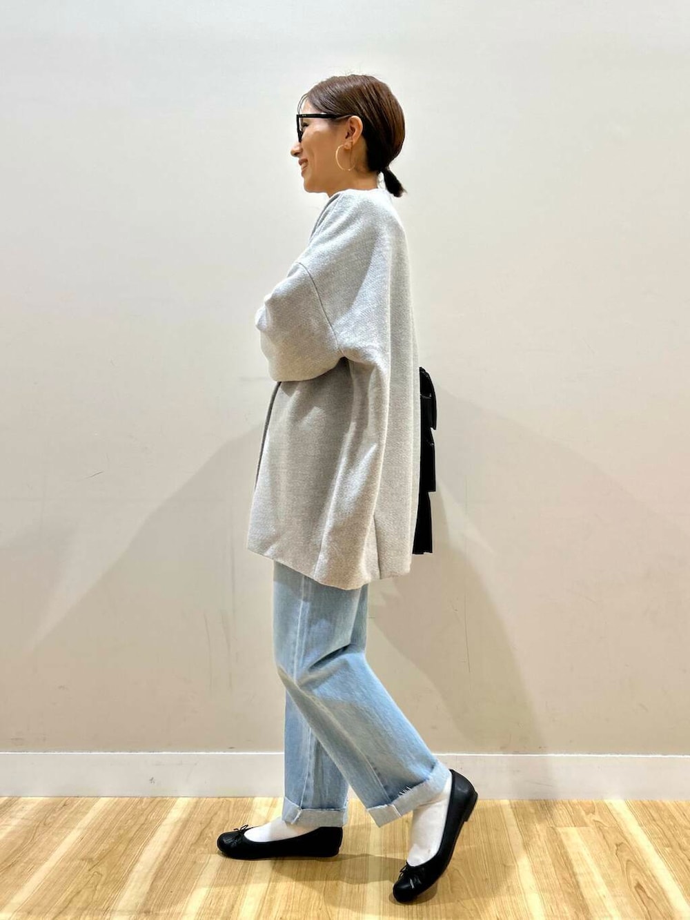 ブラック系のトートバッグ、ブルー系のデニムパンツ、グレー系のノーカラージャケットを着用したレディースの冬コーディネートの2枚目の写真