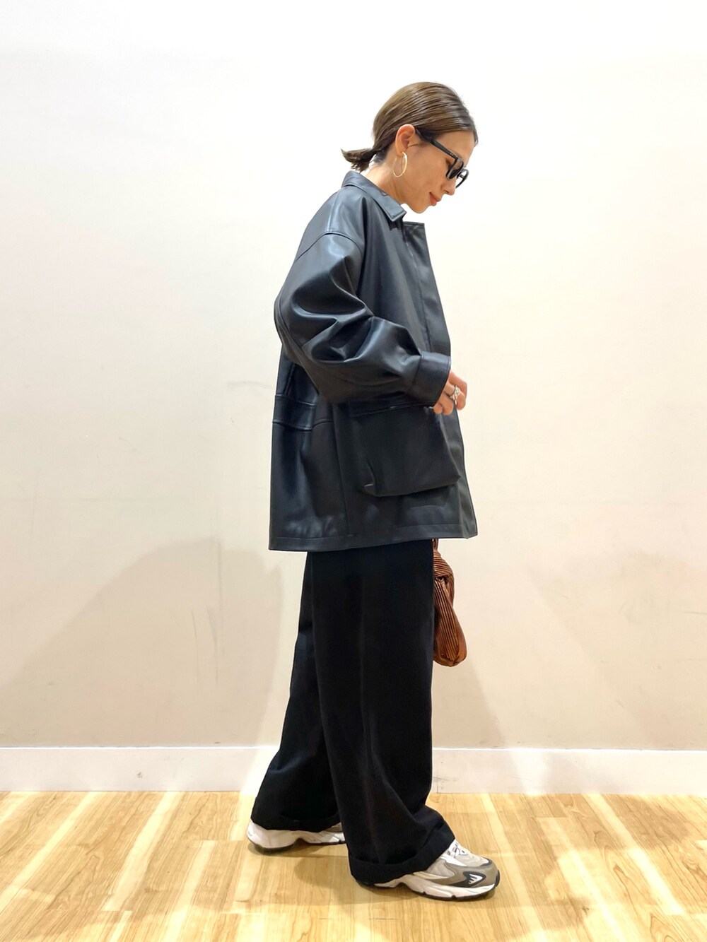 ブラック系のその他アウター、ホワイト系のニット/セーター、ブラック系のチノパンツを着用したレディースの秋コーディネートの2枚目の写真