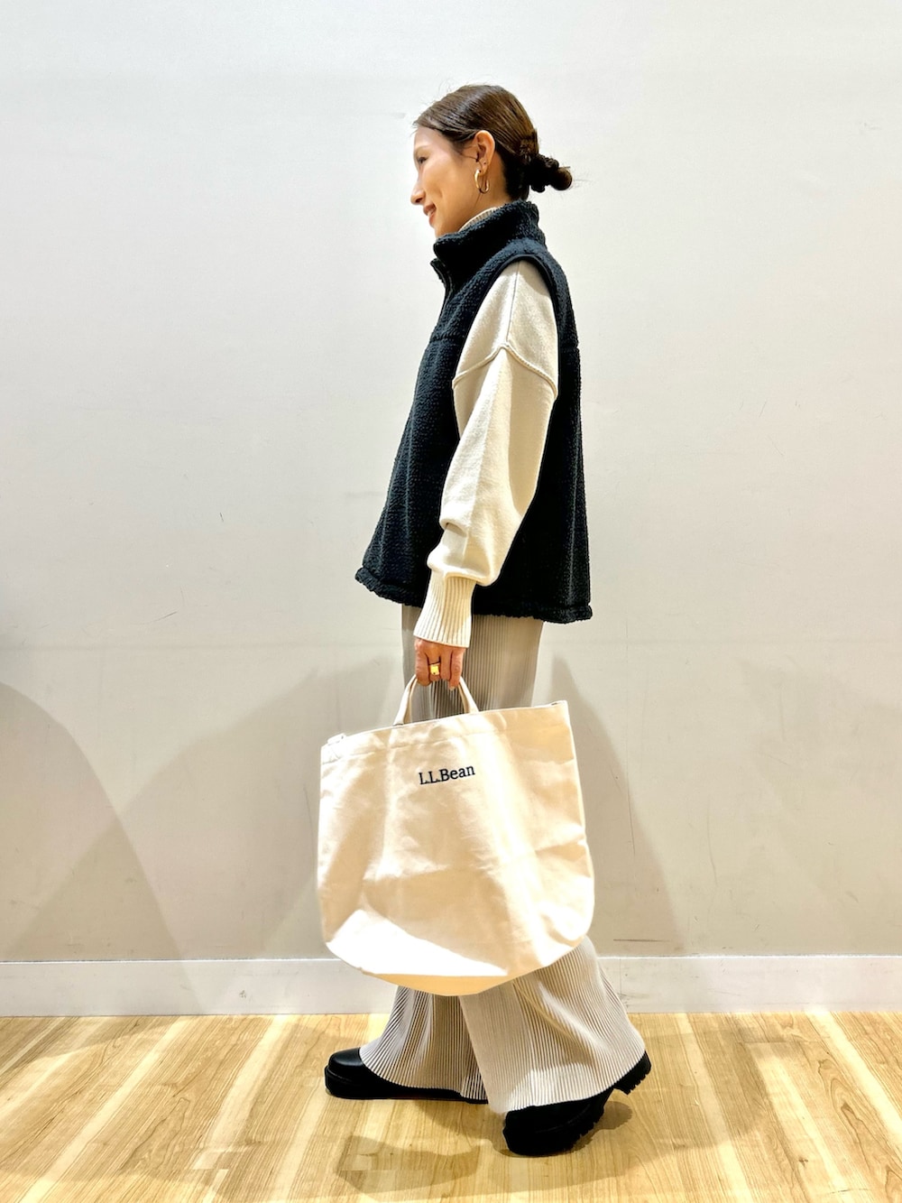 グレー系のベスト、グリーン系のダウンジャケット/コート、ホワイト系のニット/セーターを着用したレディースの冬コーディネートの5枚目の写真