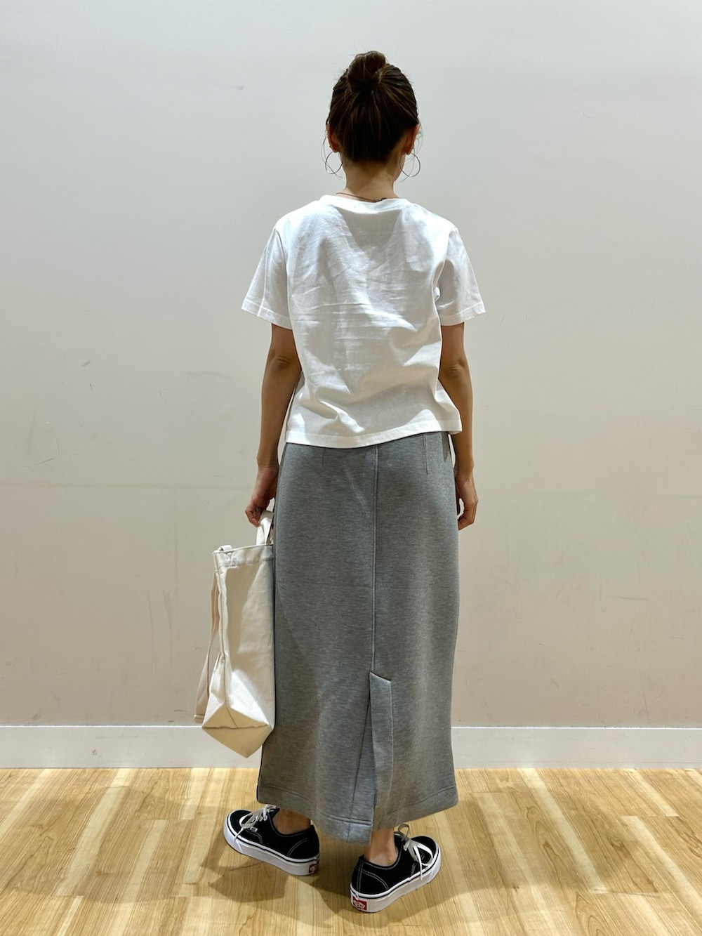 イエロー系のカーディガン/ボレロ、ホワイト系のTシャツ/カットソー、グレー系のスカートを着用したレディースの春コーディネートの6枚目の写真