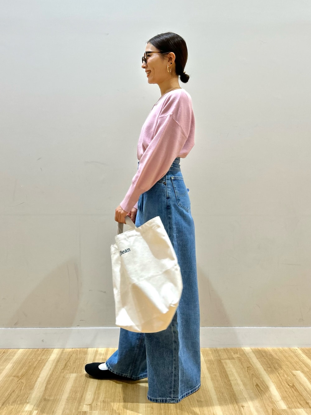 ブルー系のデニムパンツ、ベージュ系のショルダーバッグ、ピンク系のニット/セーターを着用したレディースの冬コーディネートの6枚目の写真