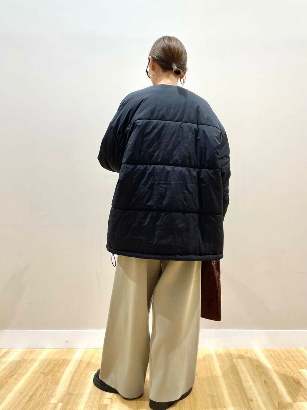 ホワイト系のニット/セーター、ブラック系のダウンジャケット/コート、ベージュ系のその他パンツを着用したレディースの冬コーディネートの4枚目の写真