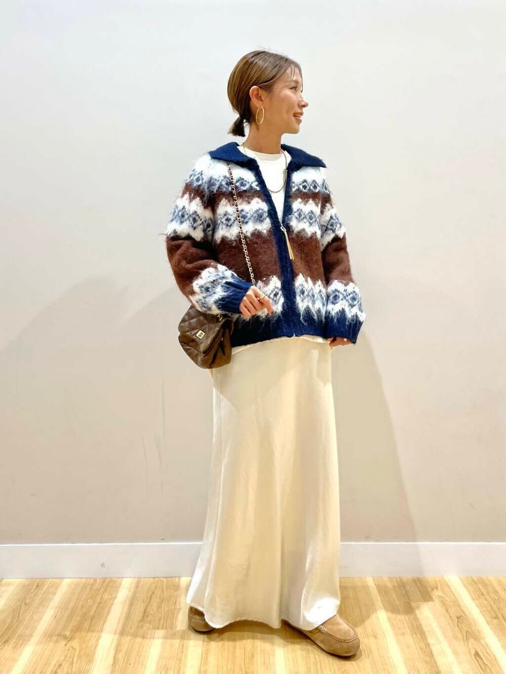 ブルー系のカーディガン/ボレロ、ホワイト系のスウェット、ブラウン系のショルダーバッグを着用したレディースの秋コーディネートの2枚目の写真