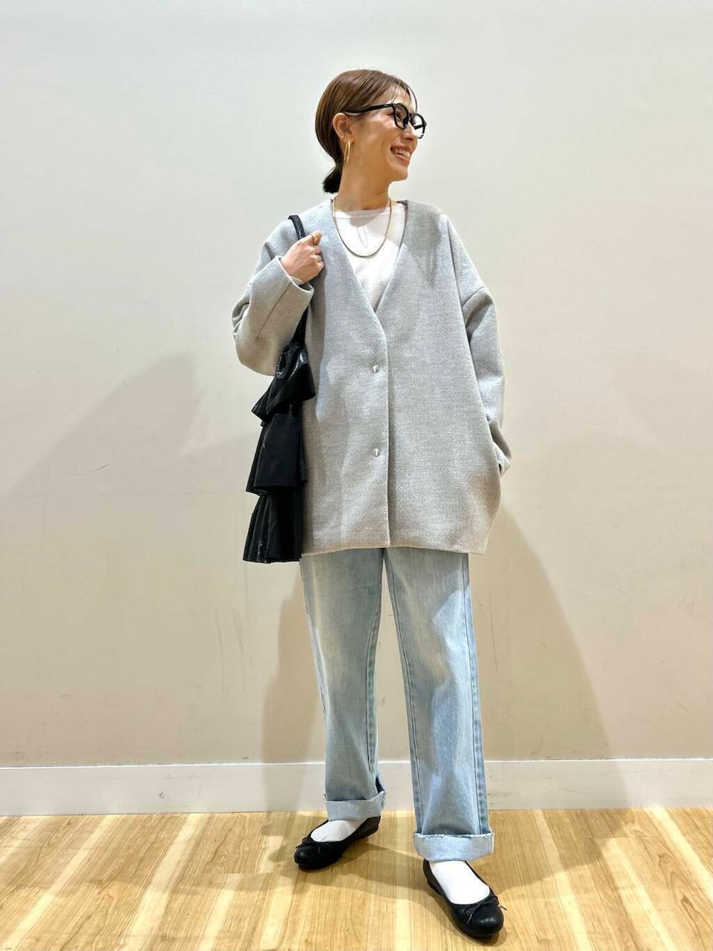 ブラック系のトートバッグ、ブルー系のデニムパンツ、グレー系のノーカラージャケットを着用したレディースの冬コーディネートの6枚目の写真