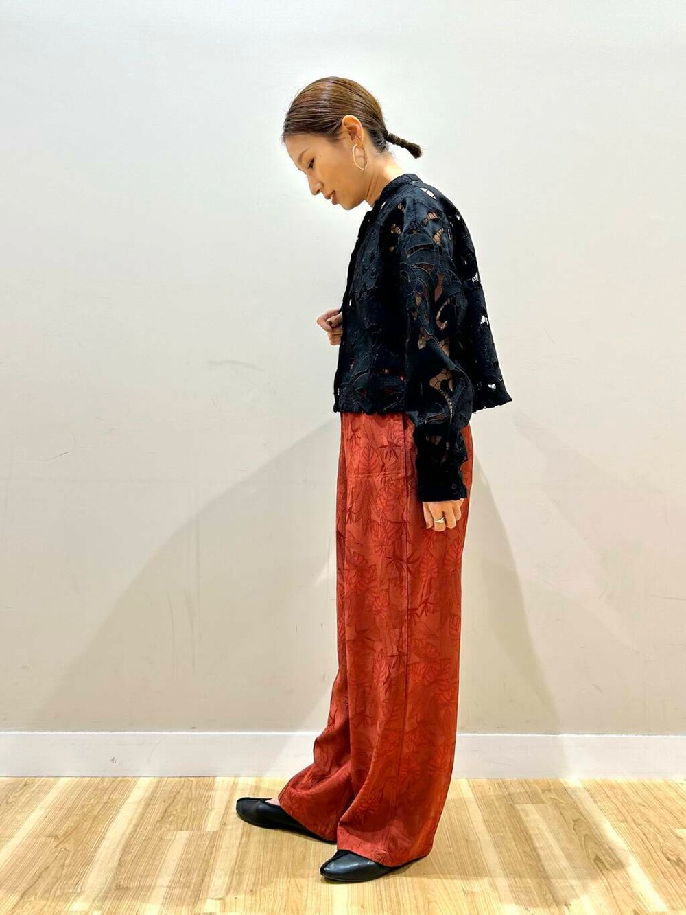 ブラック系のショルダーバッグ、オレンジ系のその他パンツ、ブラック系のシャツ/ブラウスを着用したレディースの春コーディネートの2枚目の写真