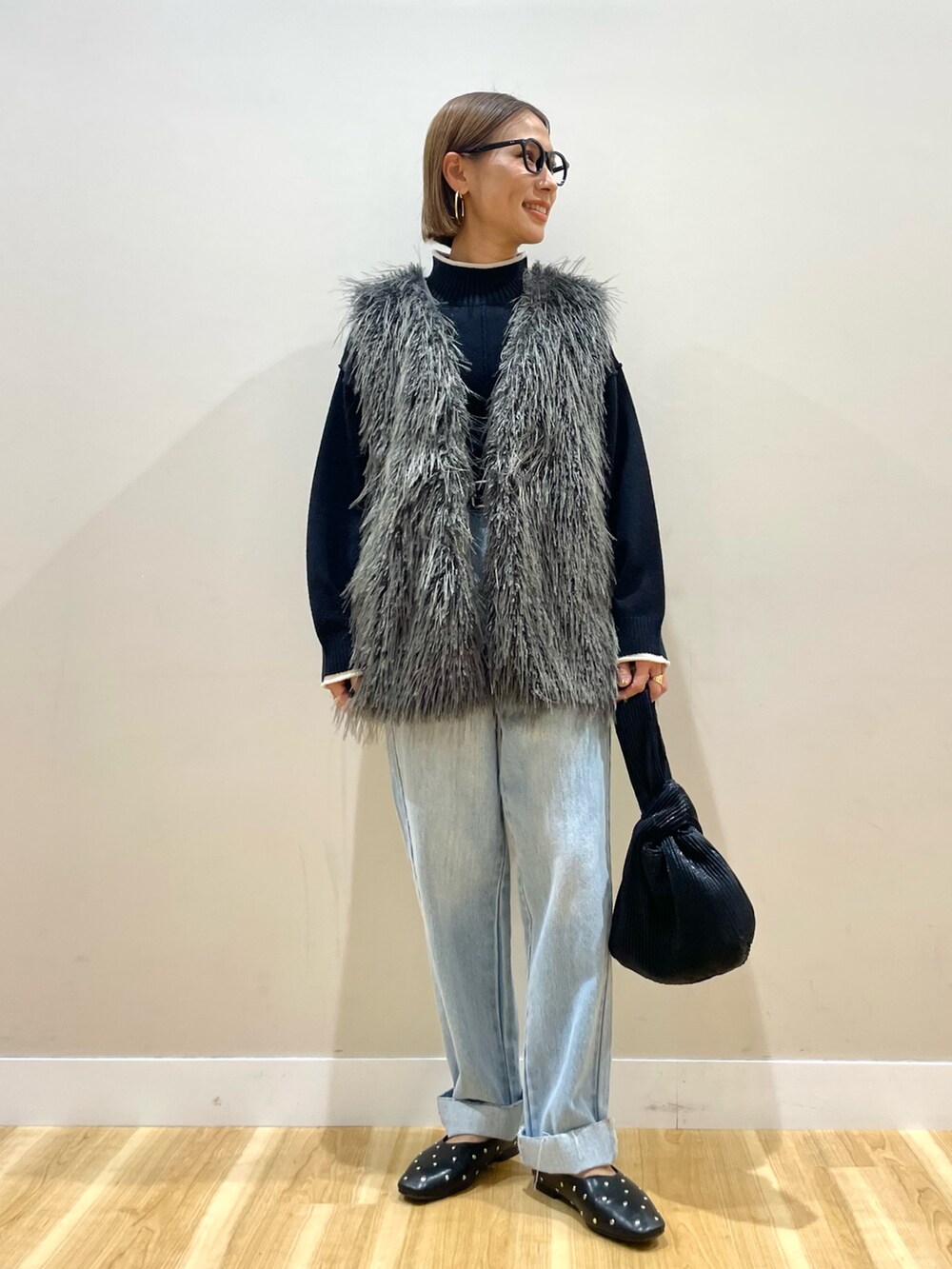 グレー系のその他アウター、ブラック系のニット/セーター、ブルー系のデニムパンツを着用したレディースの秋コーディネートの2枚目の写真