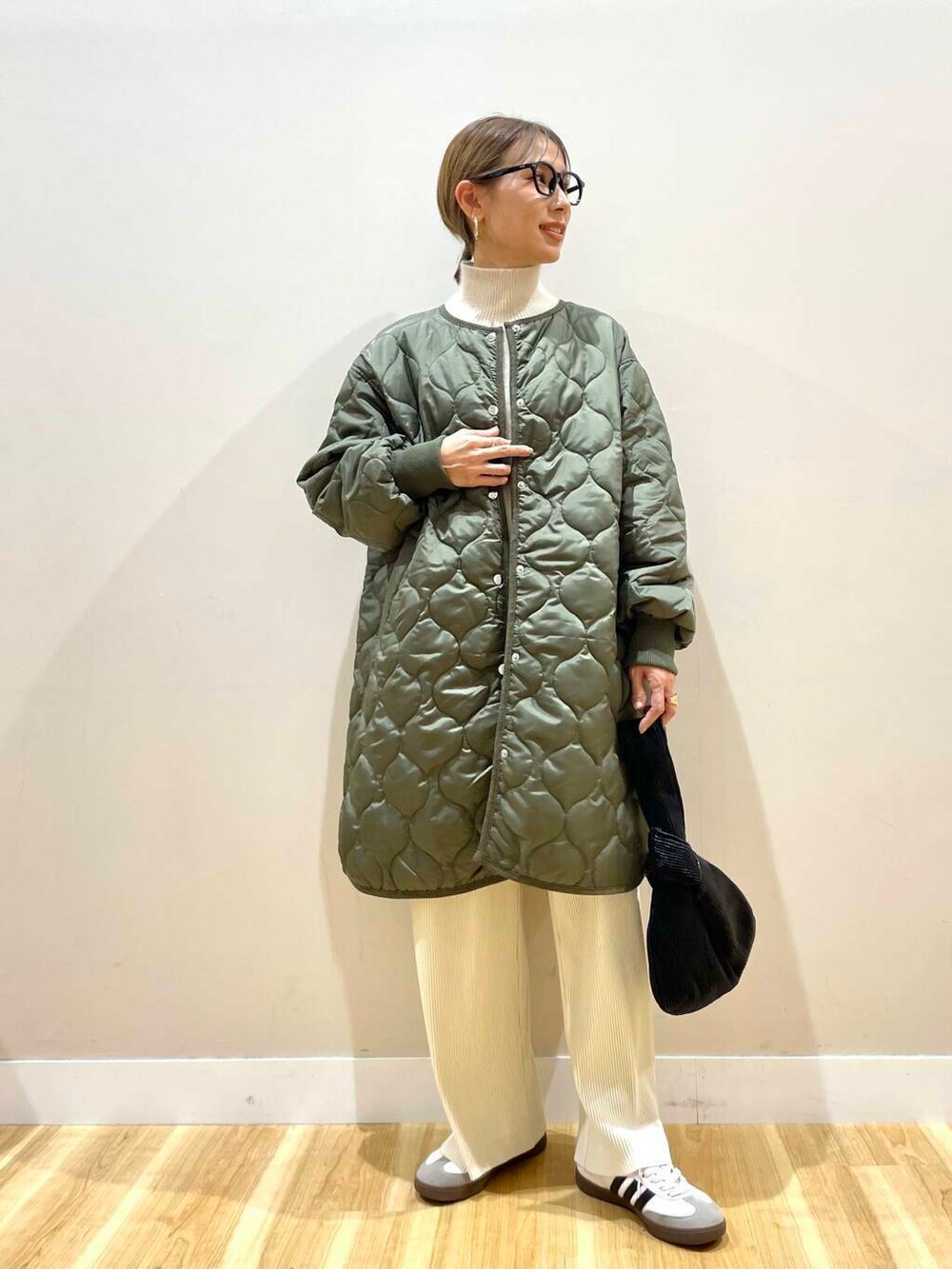 ホワイト系のその他パンツ、ブラック系のハンドバッグ、グリーン系のその他アウターを着用したレディースの冬コーディネートの2枚目の写真