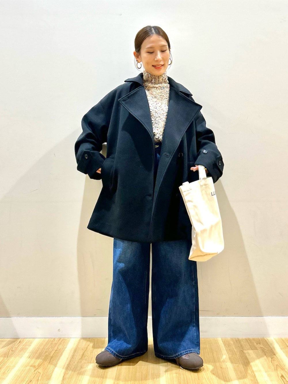 ブラック系のその他アウター、ベージュ系のニット/セーター、ブラウン系のスニーカーを着用したレディースの冬コーディネートの7枚目の写真