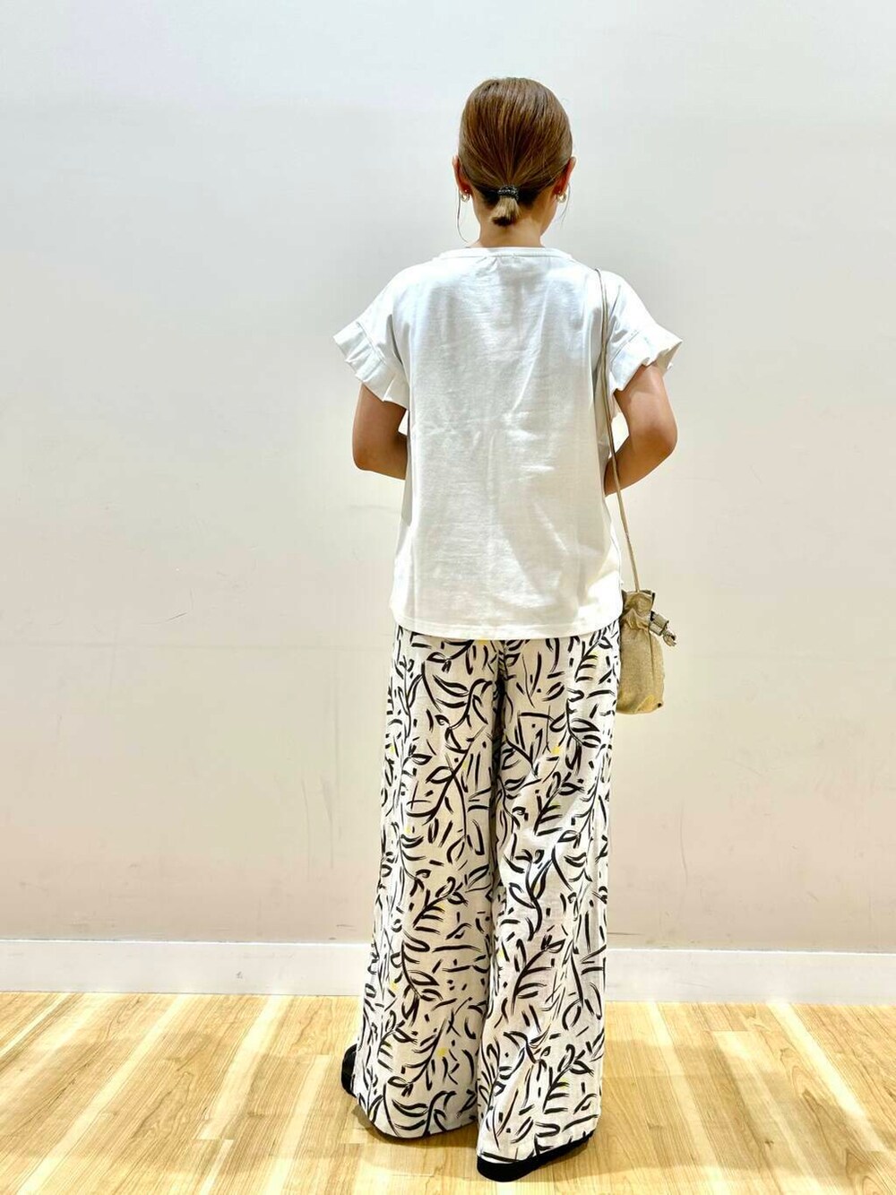 ゴールド系のショルダーバッグ、ホワイト系のその他パンツ、ホワイト系のTシャツ/カットソーを着用したレディースの夏コーディネートの9枚目の写真