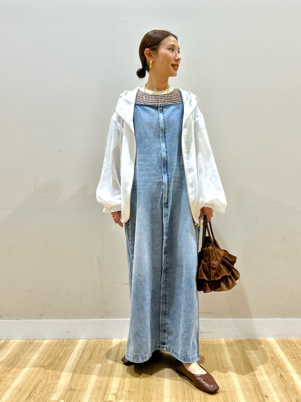 ホワイト系のマウンテンパーカー、ブラウン系のニット/セーター、ブルー系のワンピースを着用したレディースの春コーディネートの4枚目の写真