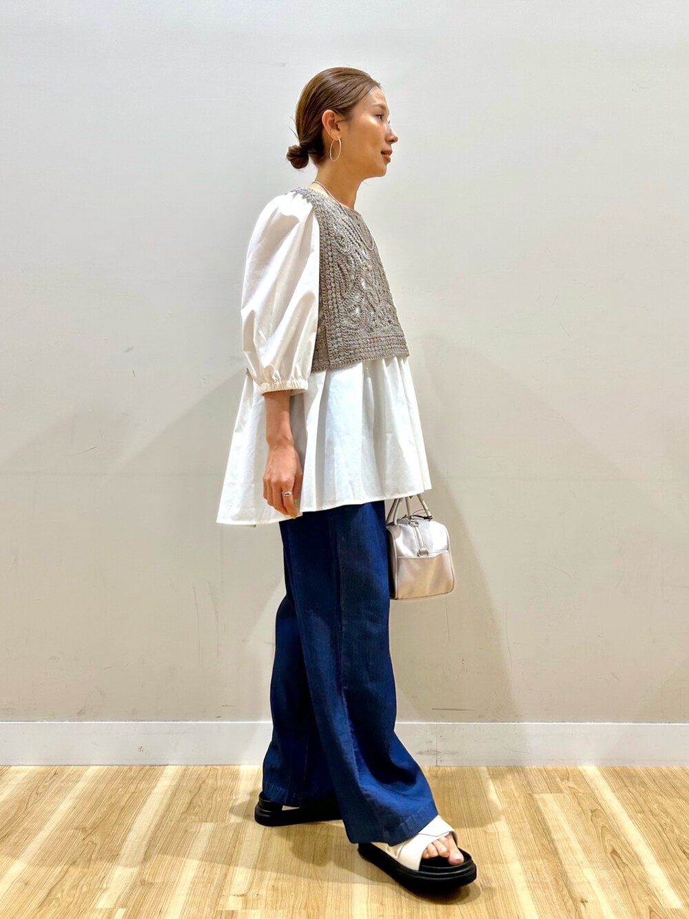 ベージュ系のシャツ/ブラウス、ブルー系のその他パンツ、ホワイト系のボストンバッグを着用したレディースの春コーディネートの2枚目の写真