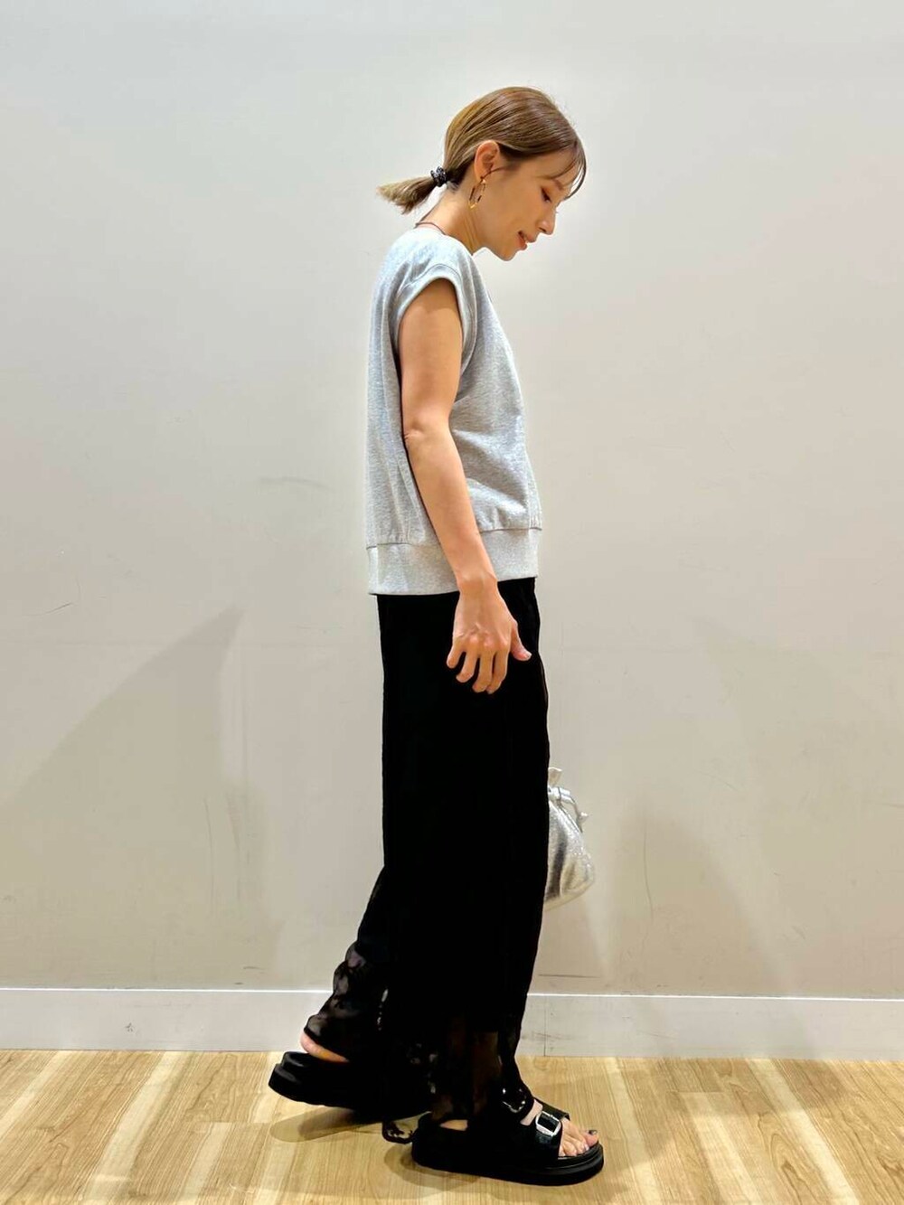 シルバー系のショルダーバッグ、ブラック系のその他パンツ、グレー系のベストを着用したレディースの夏コーディネートの2枚目の写真