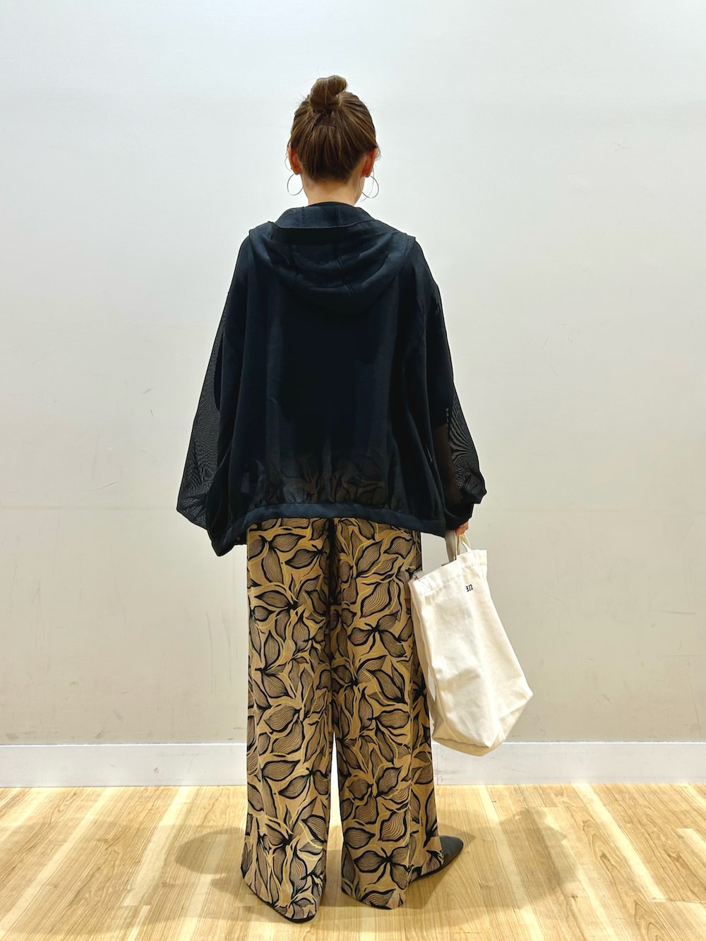 ブラック系のマウンテンパーカー、ブラック系のニット/セーター、ブラウン系のその他パンツを着用したレディースの春コーディネートの3枚目の写真