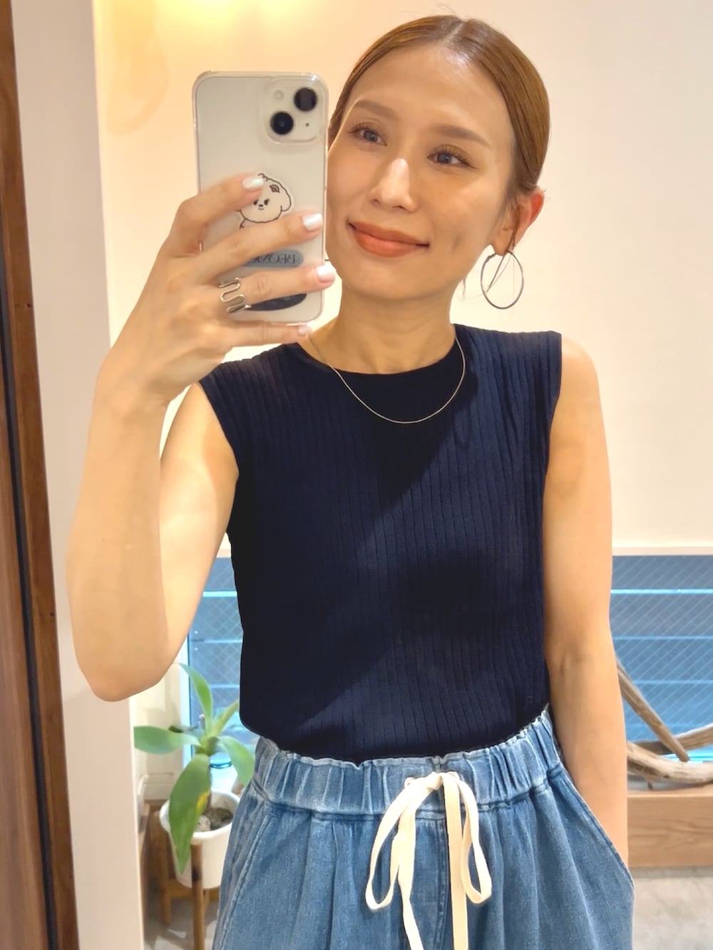 ブルー系のニット/セーター、ブルー系のデニムパンツ、ブラック系のサンダルを着用したレディースの夏コーディネートの4枚目の写真