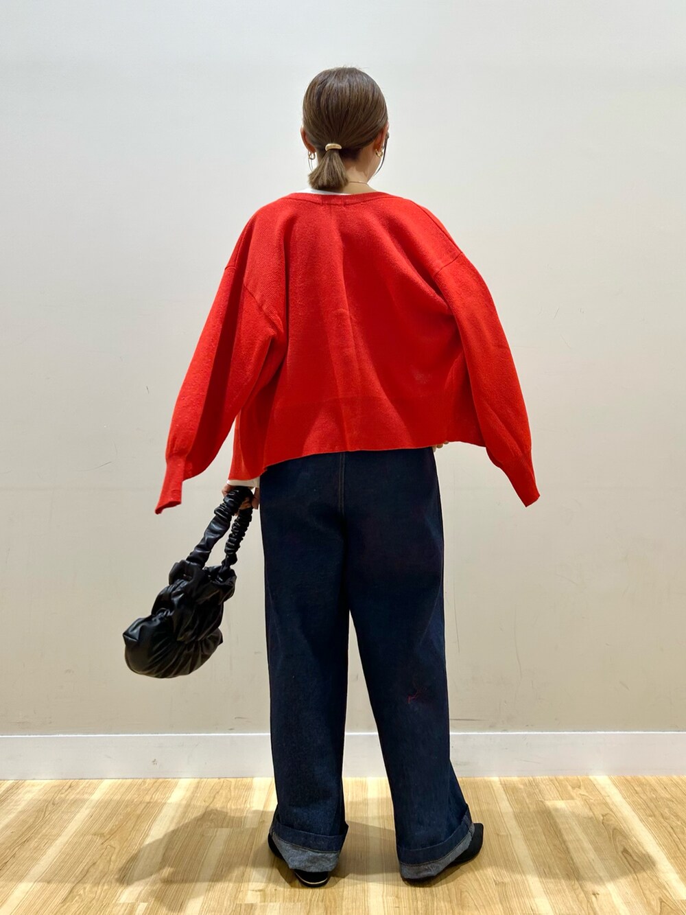 ホワイト系のTシャツ/カットソー、レッド系のカーディガン/ボレロ、ブルー系のデニムパンツを着用したレディースの秋コーディネートの3枚目の写真