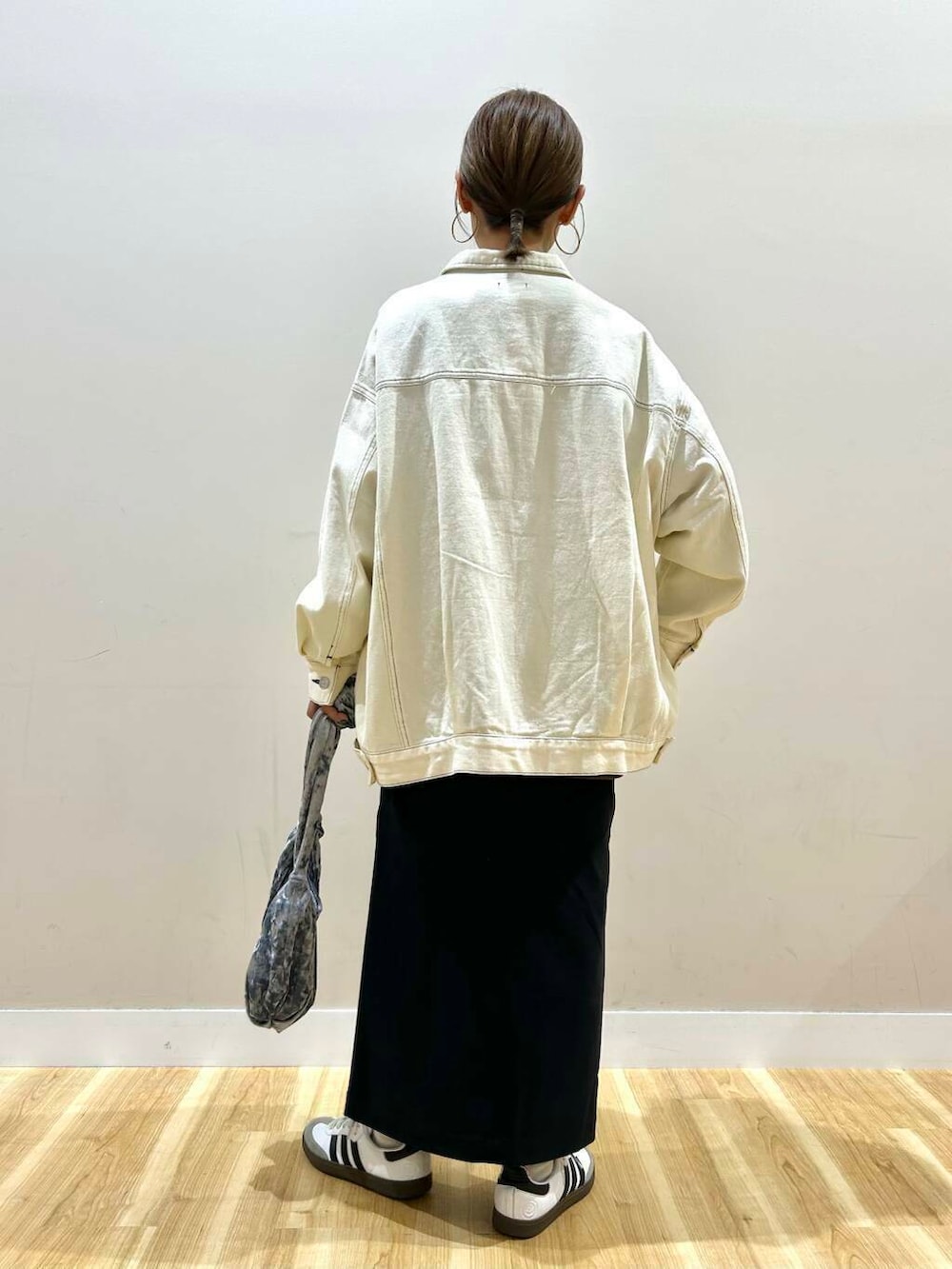 グレー系のハンドバッグ、ブラック系のニット/セーター、ブラック系のスカートを着用したレディースの冬コーディネートの4枚目の写真