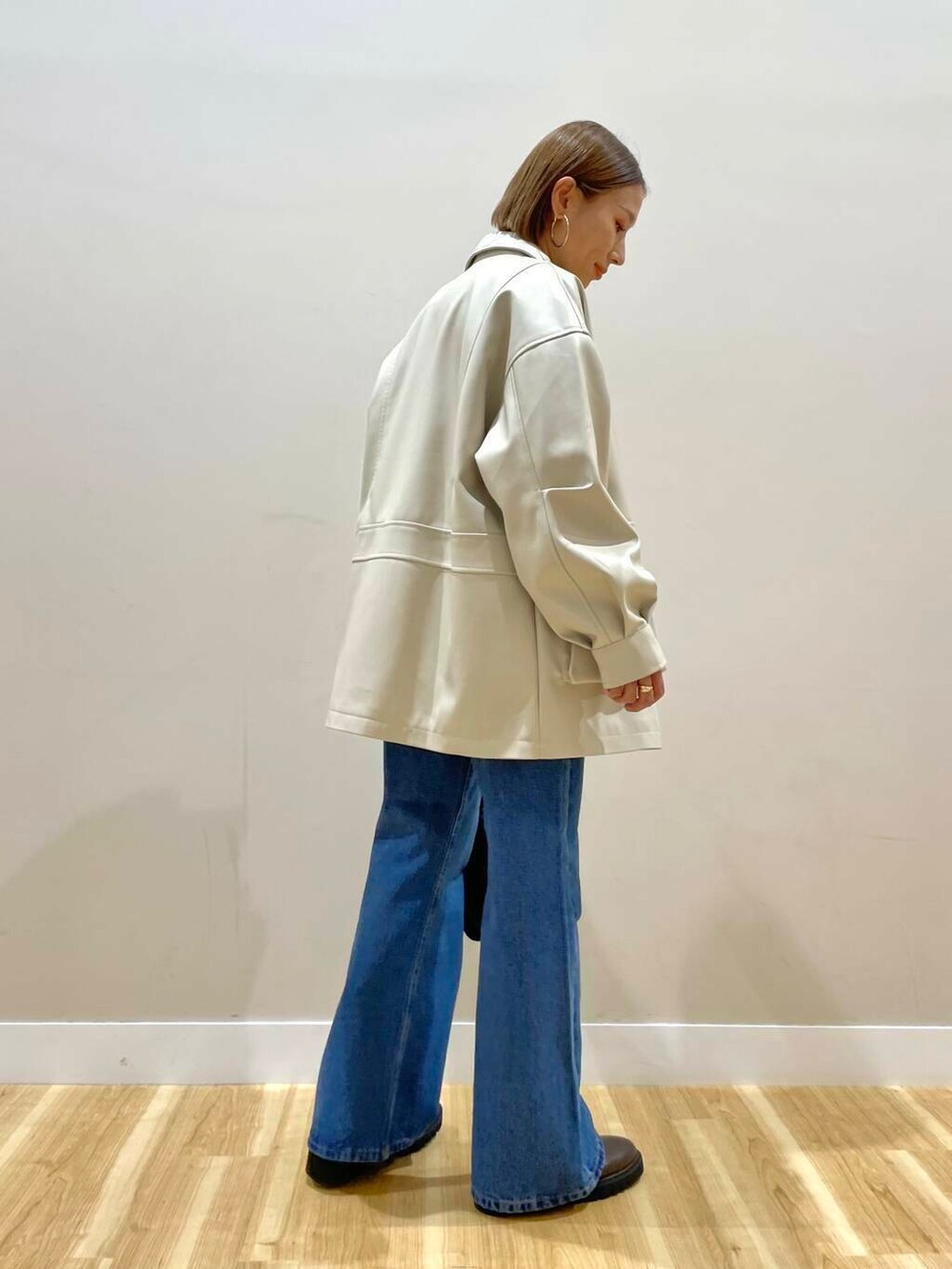 ブラウン系のブーツ、ブルー系のデニムパンツ、ブラック系のハンドバッグを着用したレディースの秋コーディネートの2枚目の写真