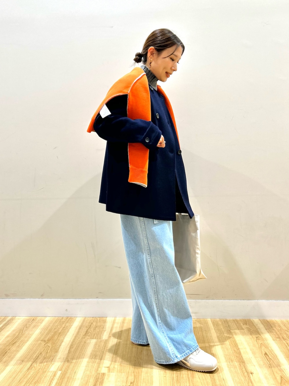 ブルー系のピーコート、グレー系のニット/セーター、オレンジ系のニット/セーターを着用したレディースの冬コーディネートの2枚目の写真