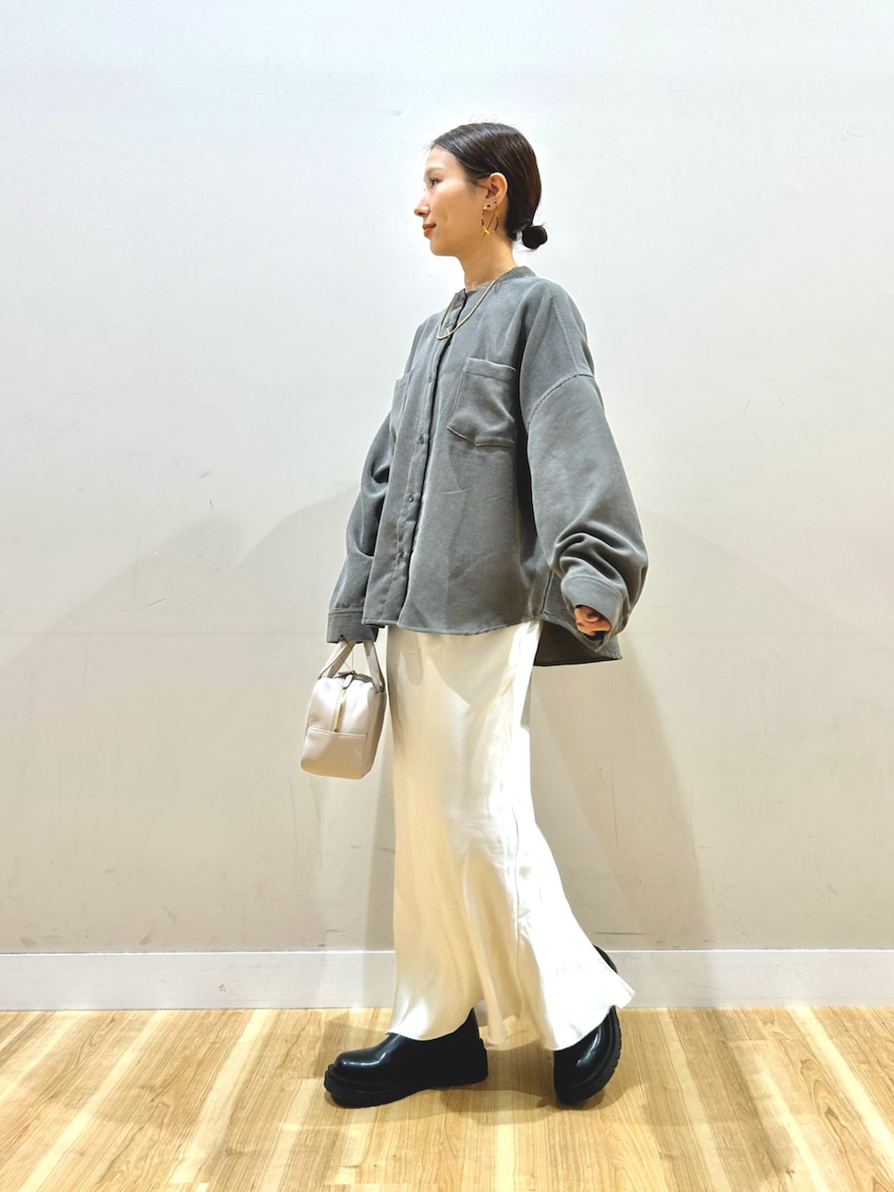 ブラック系のブルゾン、ホワイト系のスカート、グレー系のボストンバッグを着用したレディースの冬コーディネートの5枚目の写真