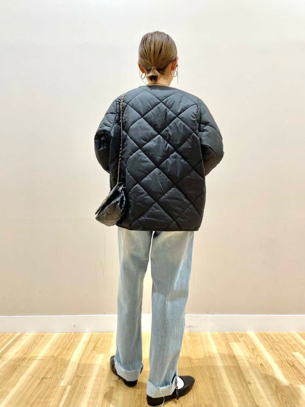 ブラック系のパンプス、ベージュ系のニット/セーター、ブルー系のデニムパンツを着用したレディースの冬コーディネートの3枚目の写真