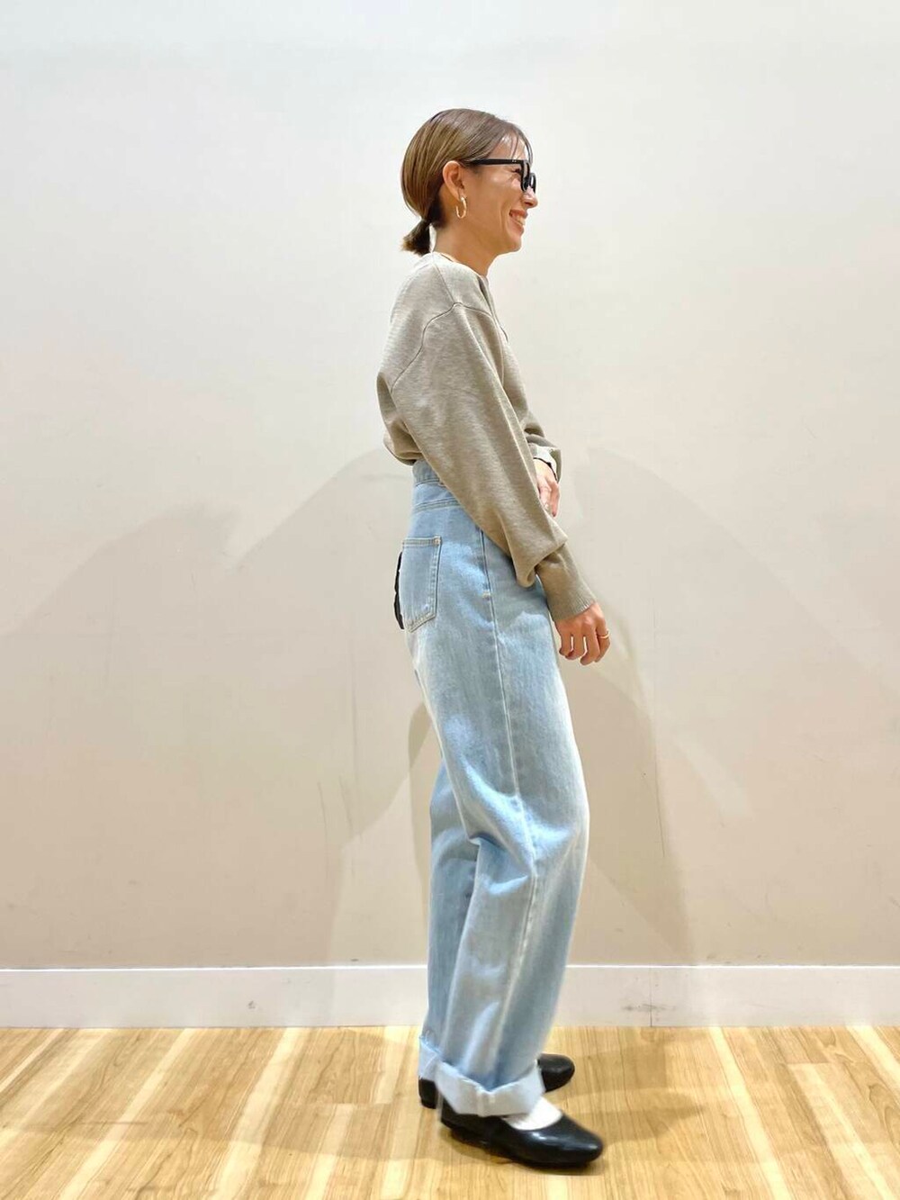 ブラック系のパンプス、ベージュ系のニット/セーター、ブルー系のデニムパンツを着用したレディースの冬コーディネートの10枚目の写真