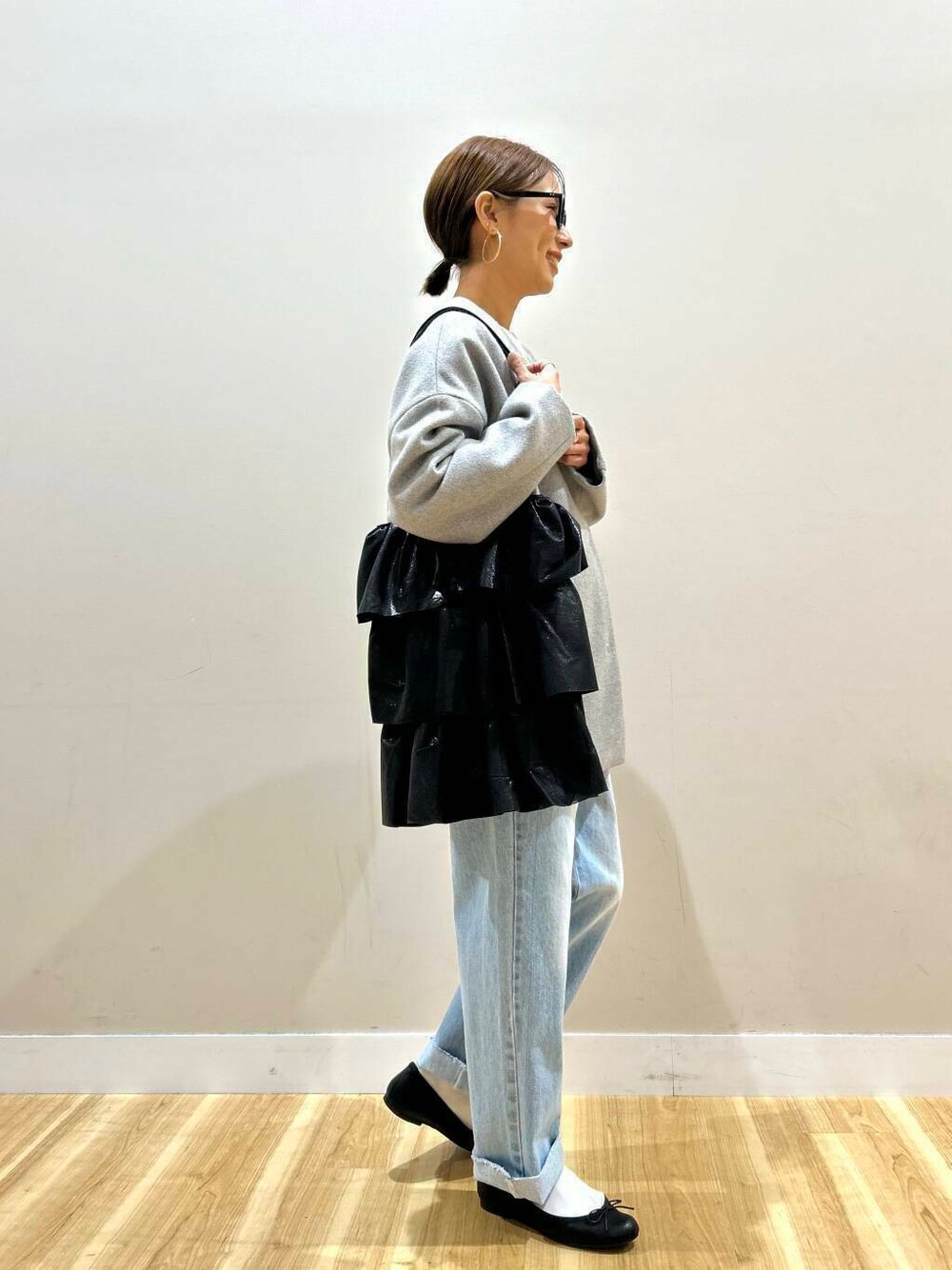 ブラック系のトートバッグ、ブルー系のデニムパンツ、グレー系のノーカラージャケットを着用したレディースの冬コーディネートの5枚目の写真