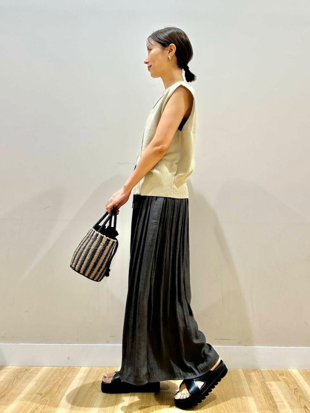 ブラック系のハンドバッグ、グレー系のその他パンツ、ブラック系のサンダルを着用したレディースの夏コーディネートの2枚目の写真