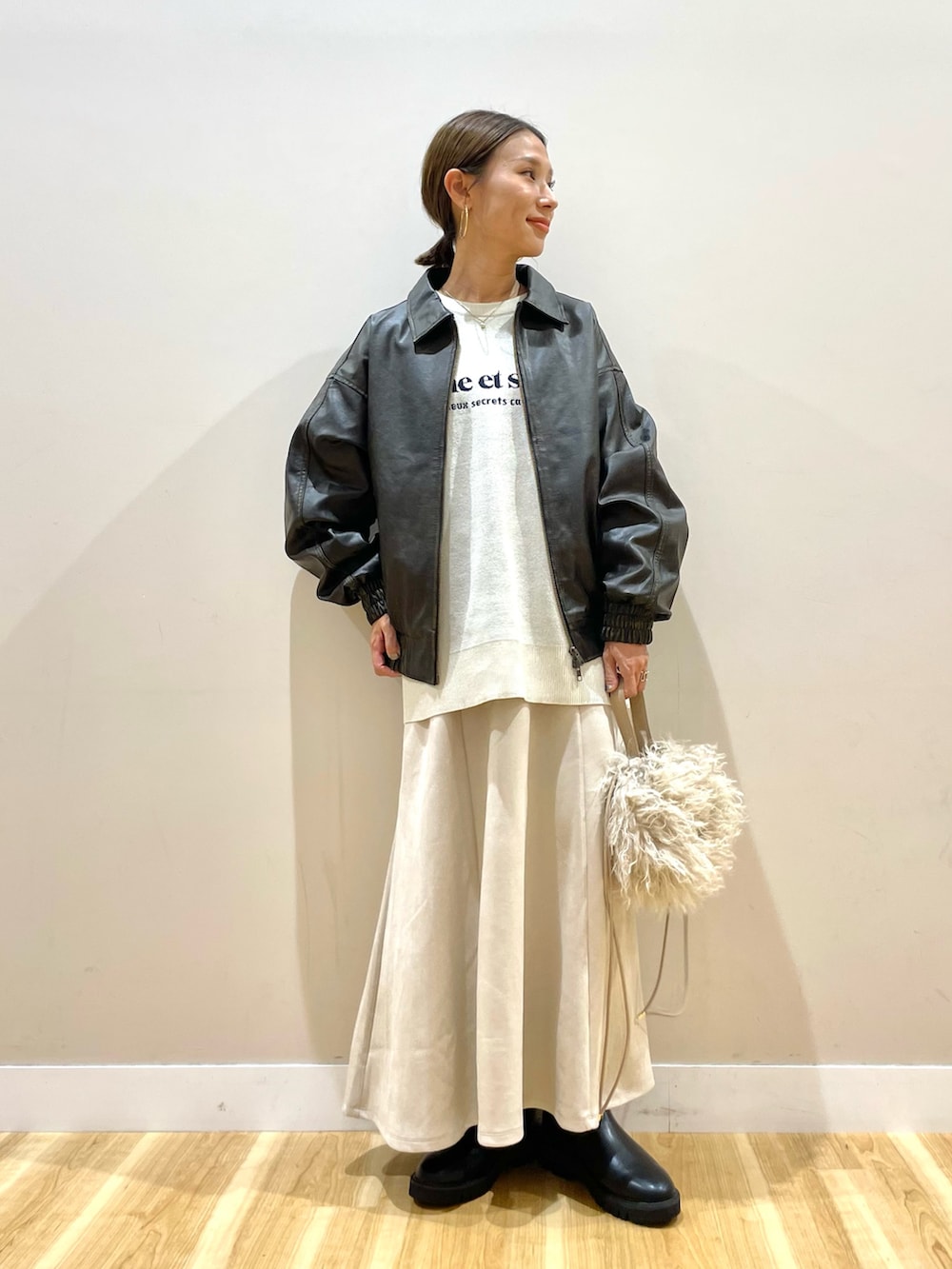 ブラウン系のその他アウター、ホワイト系のニット/セーター、ベージュ系のスカートを着用したレディースの秋コーディネートの6枚目の写真