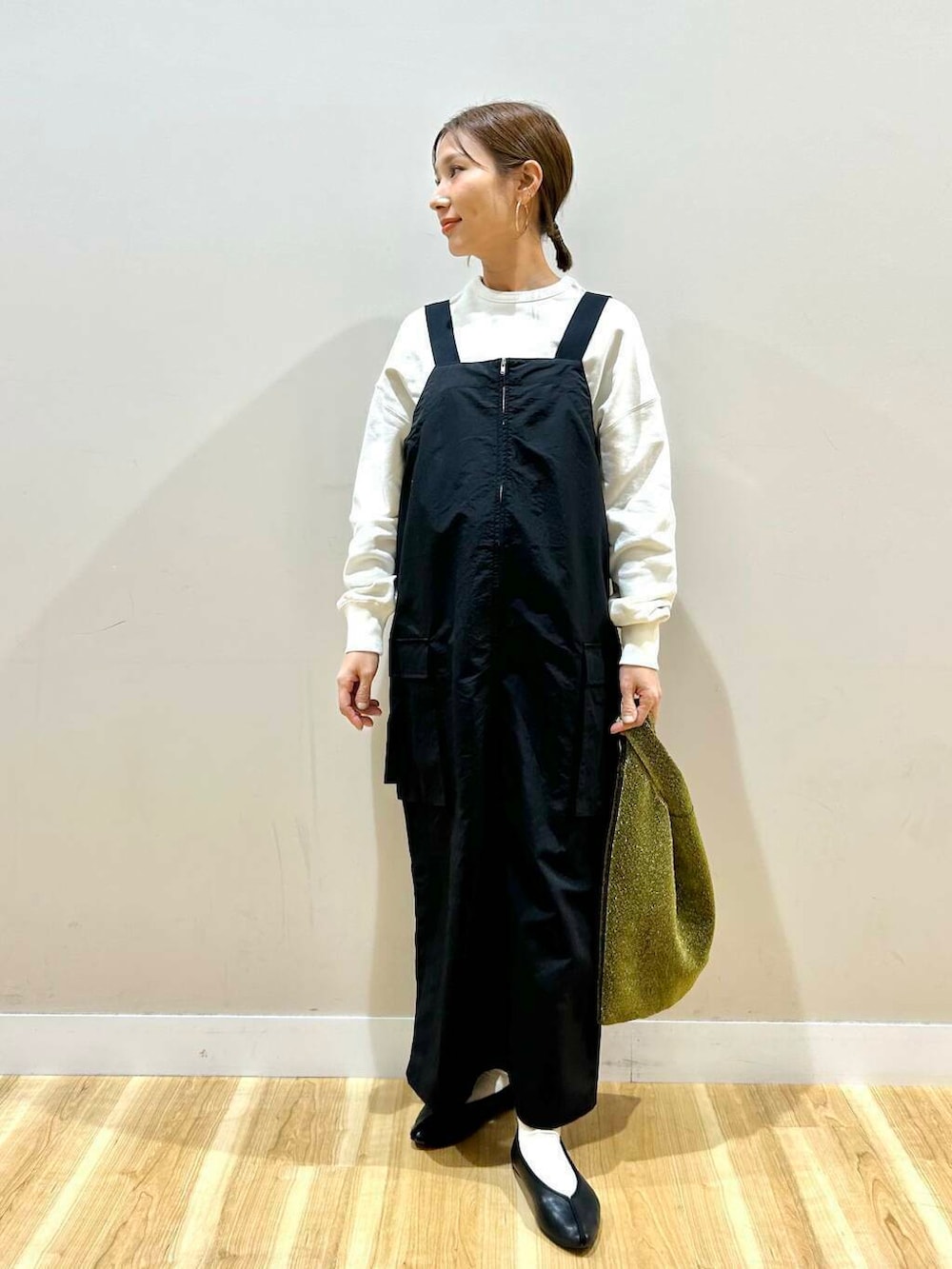 ゴールド系のトートバッグ、ベージュ系のマウンテンパーカー、ホワイト系のスウェットを着用したレディースの冬コーディネートの5枚目の写真