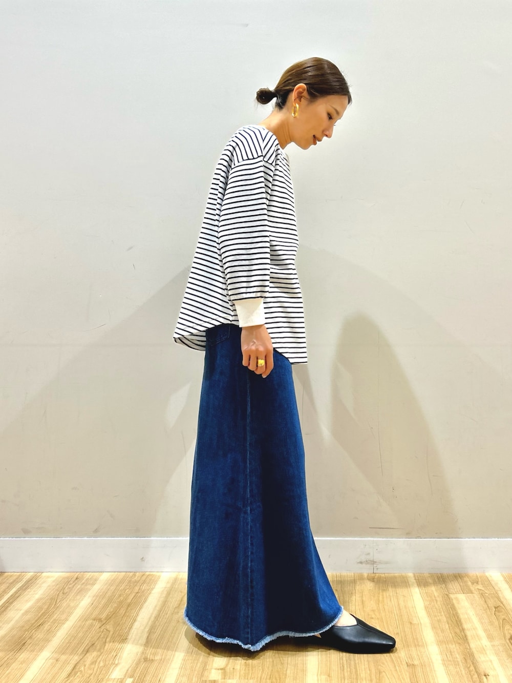 イエロー系のブルゾン、ホワイト系のTシャツ/カットソー、ブルー系のスカートを着用したレディースの春コーディネートの6枚目の写真