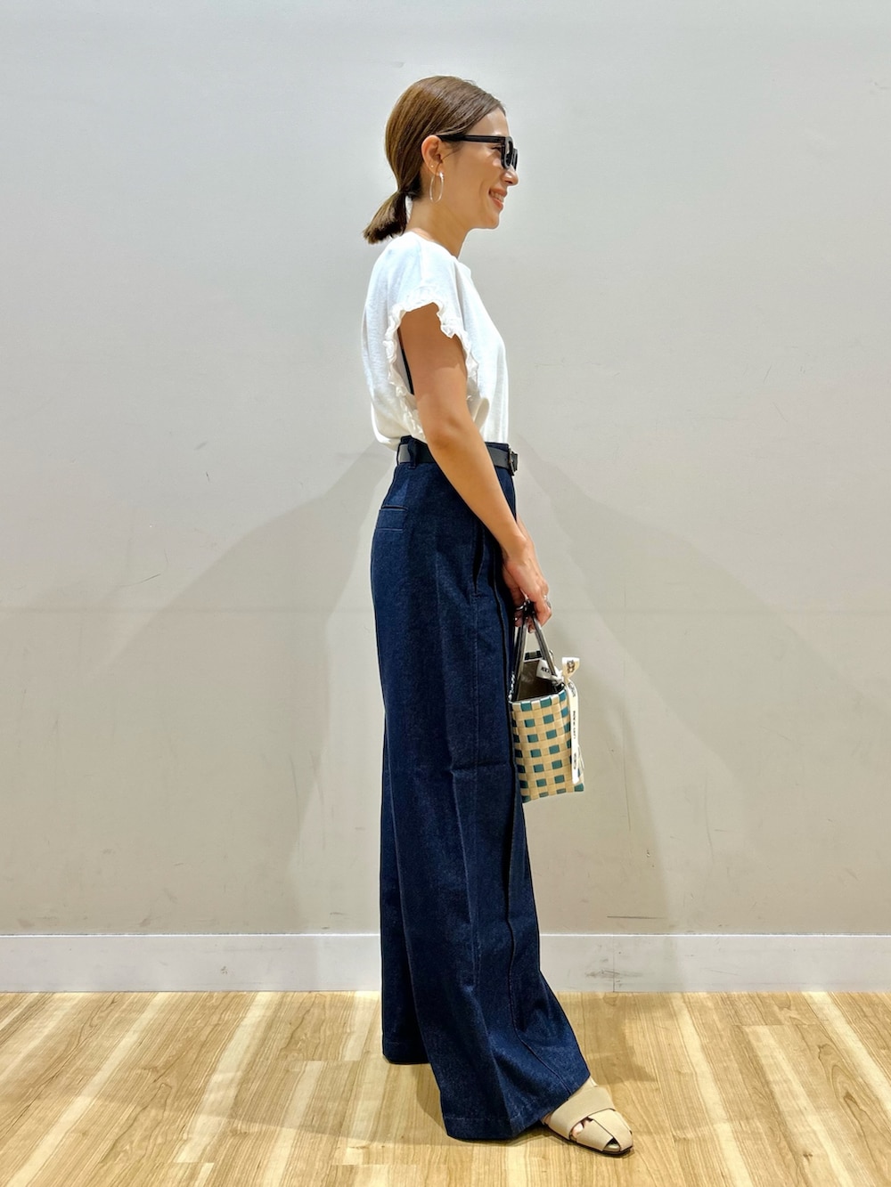 ホワイト系のTシャツ/カットソー、ブルー系のデニムパンツ、グリーン系のショルダーバッグを着用したレディースの夏コーディネートの2枚目の写真