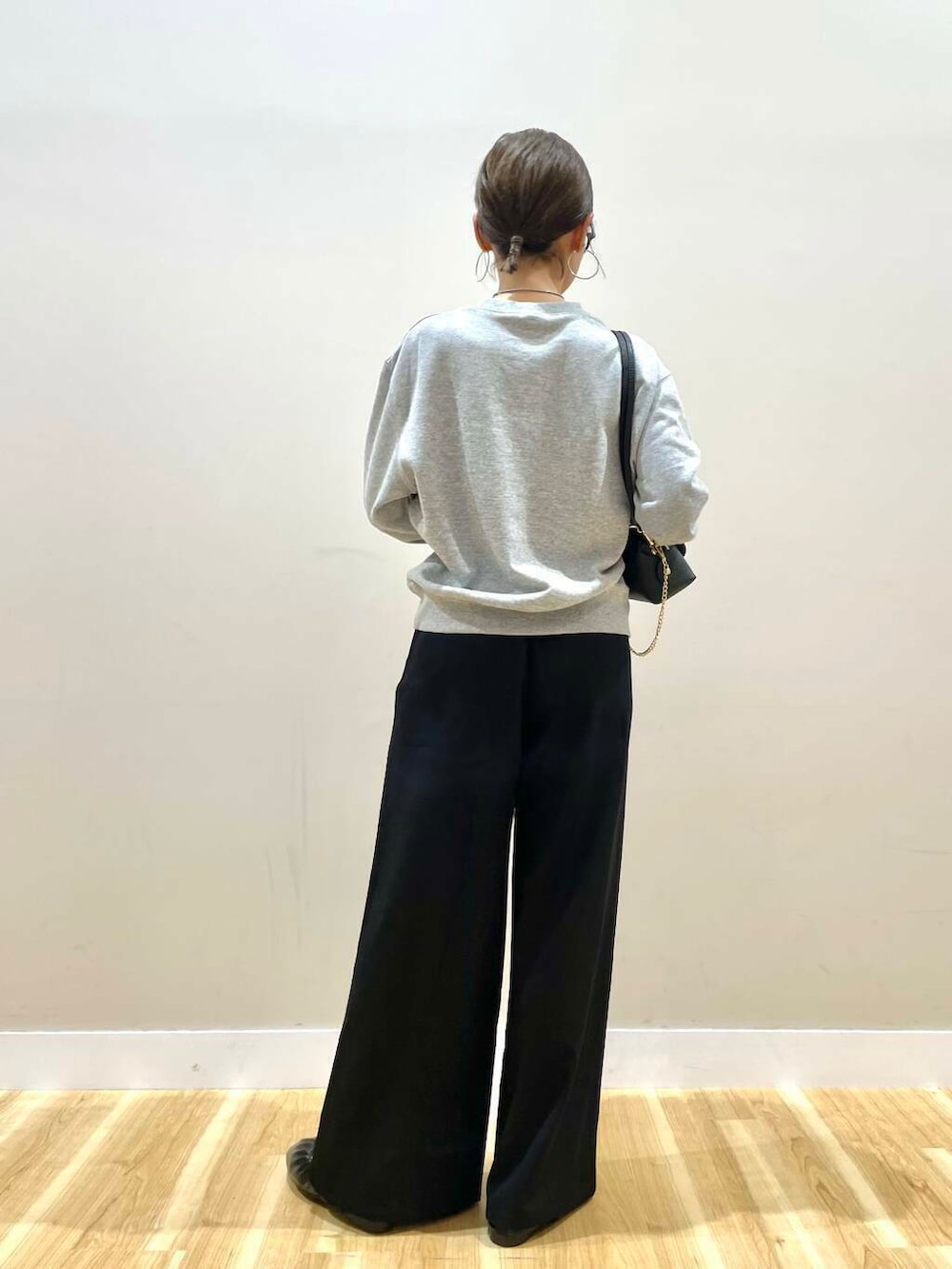 ブラック系のショルダーバッグ、ブラック系のバレエシューズ、グレー系のスウェットを着用したレディースの秋コーディネートの4枚目の写真