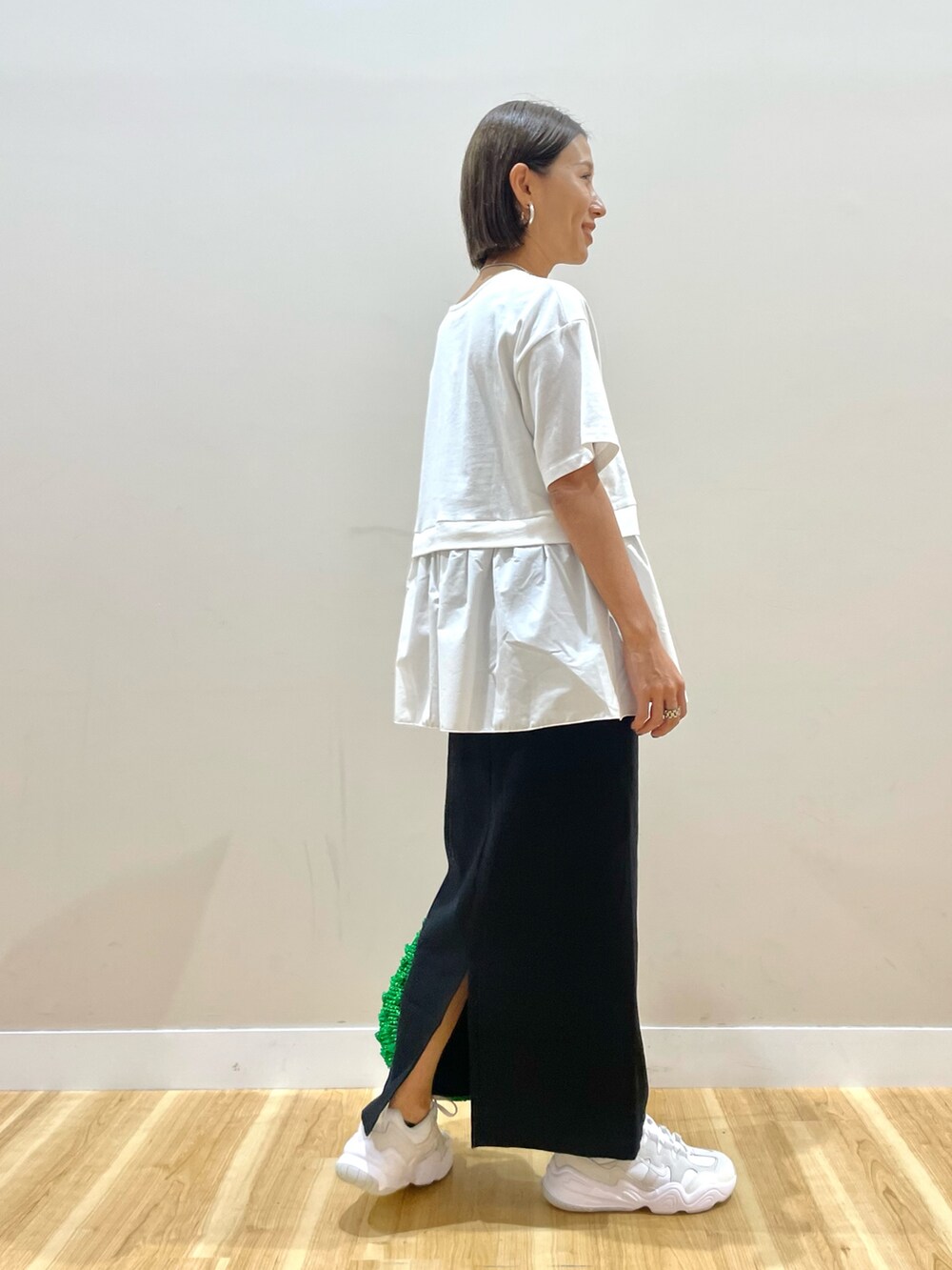 ブラック系のベスト、ホワイト系のTシャツ/カットソー、ブラック系のスカートを着用したレディースの秋コーディネートの7枚目の写真