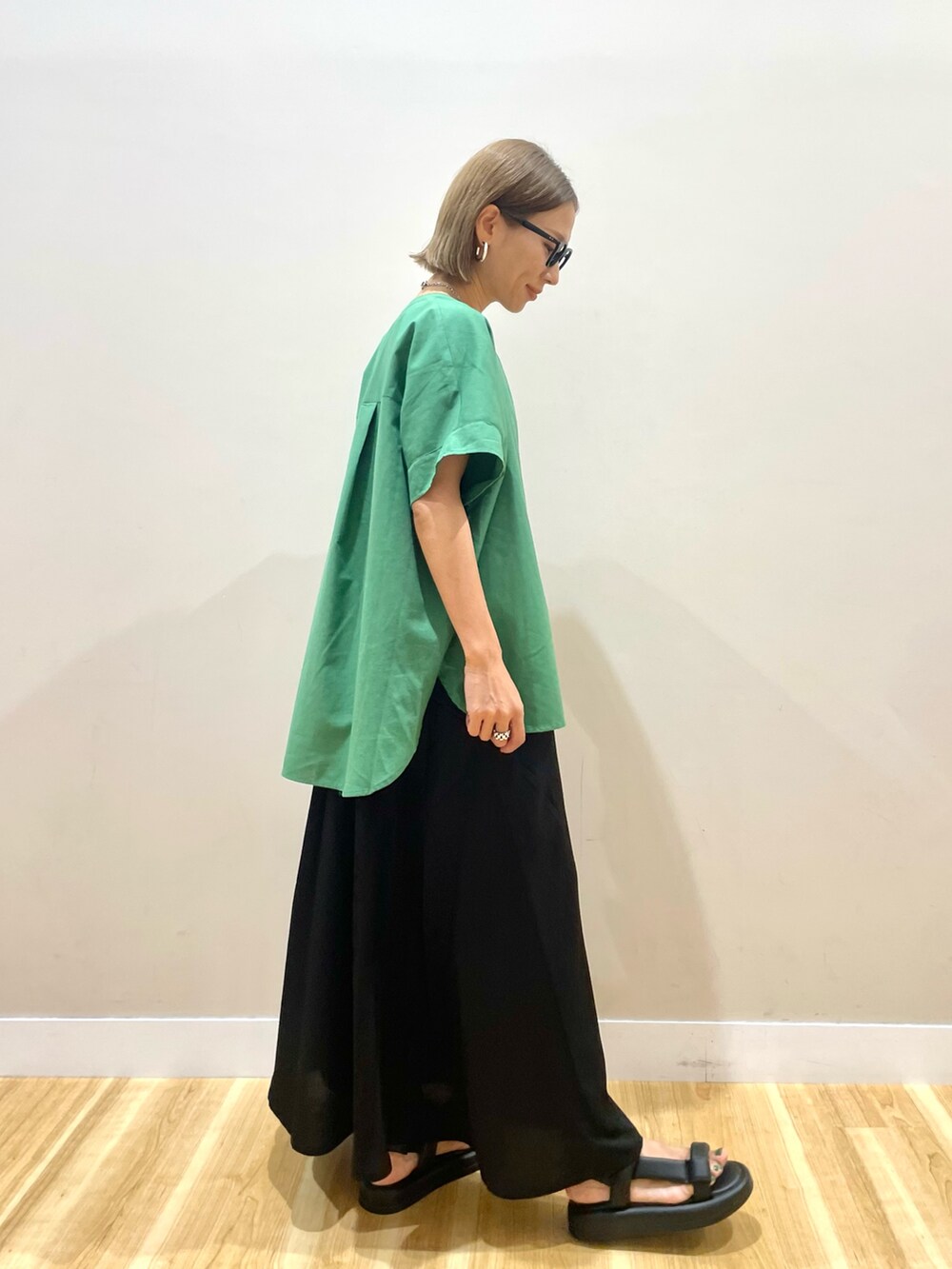 グリーン系のシャツ/ブラウス、ブラック系のワンピース、ブルー系のデニムパンツを着用したレディースの夏コーディネートの2枚目の写真