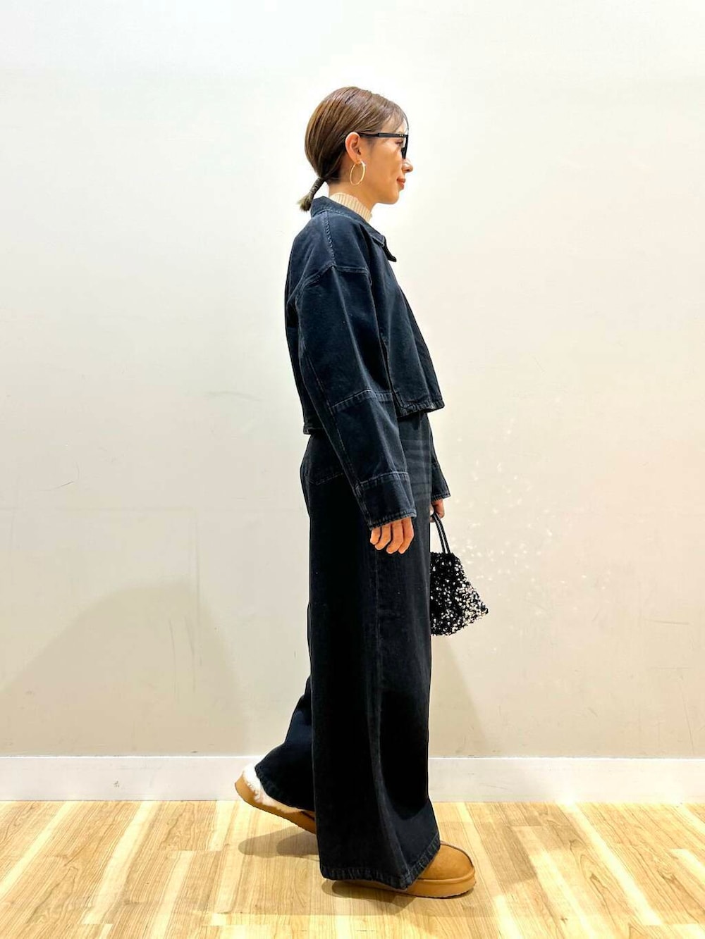 ホワイト系のニット/セーター、シルバー系のショルダーバッグ、ブラック系のデニムパンツを着用したレディースの冬コーディネートの4枚目の写真