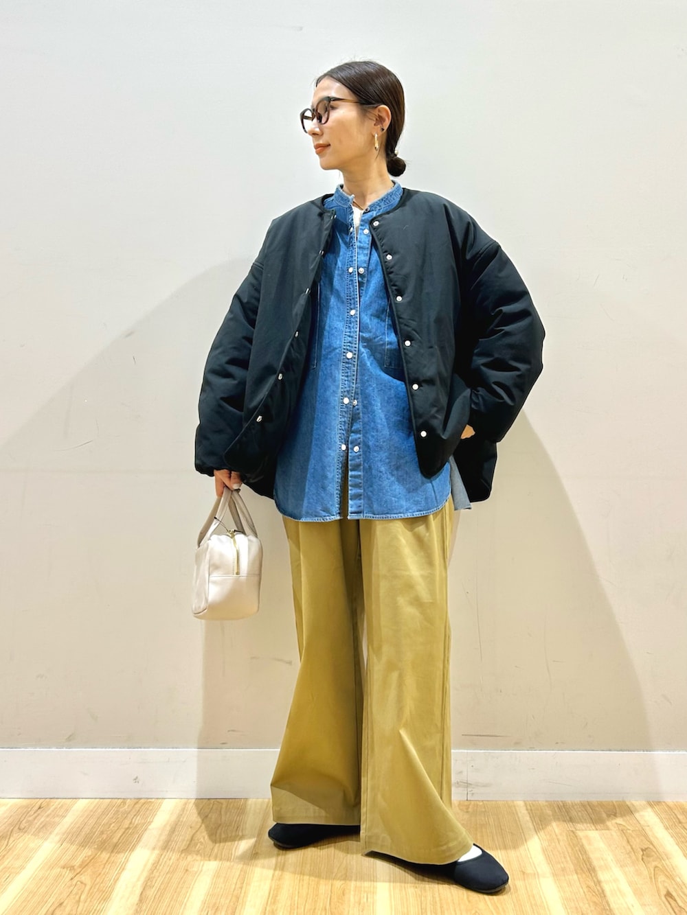 ブルー系のシャツ/ブラウス、ブラック系のダウンジャケット/コート、その他のニット/セーターを着用したレディースの冬コーディネートの2枚目の写真