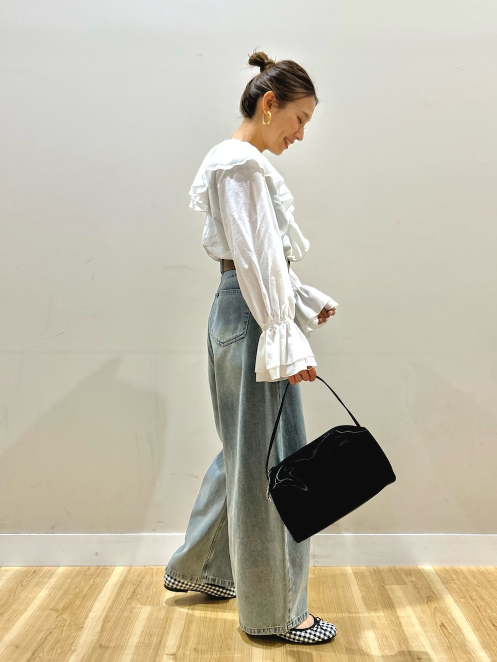 ホワイト系のシャツ/ブラウス、ブルー系のデニムパンツ、ブラック系のトートバッグを着用したレディースの春コーディネートの3枚目の写真