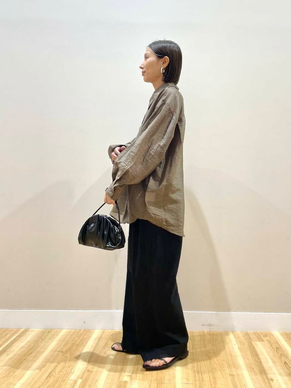 ブラック系のショルダーバッグ、ブラック系のタンクトップ、ブラウン系のシャツ/ブラウスを着用したレディースの秋コーディネートの2枚目の写真